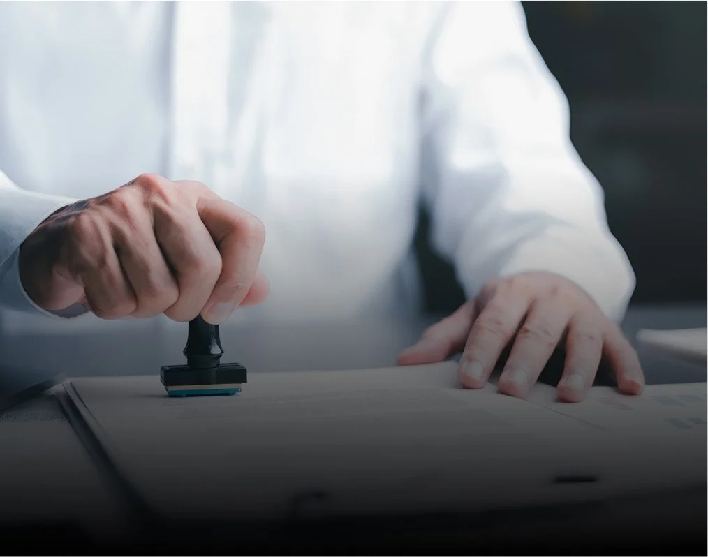 Personne apposant un tampon en caoutchouc sur un document