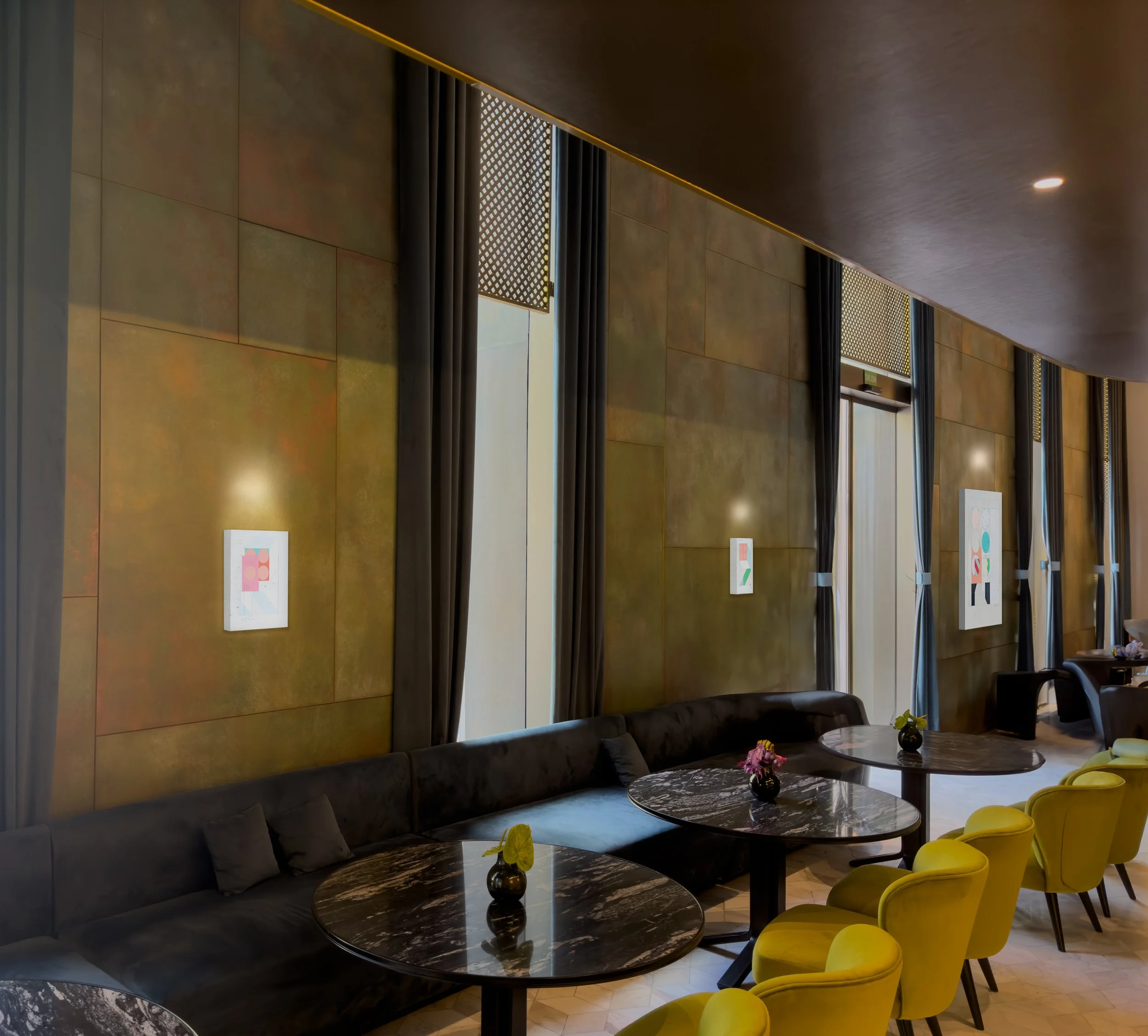 Works by Alberto Ruiz Villar installed along the wall of a Barcelona restaurant interior.