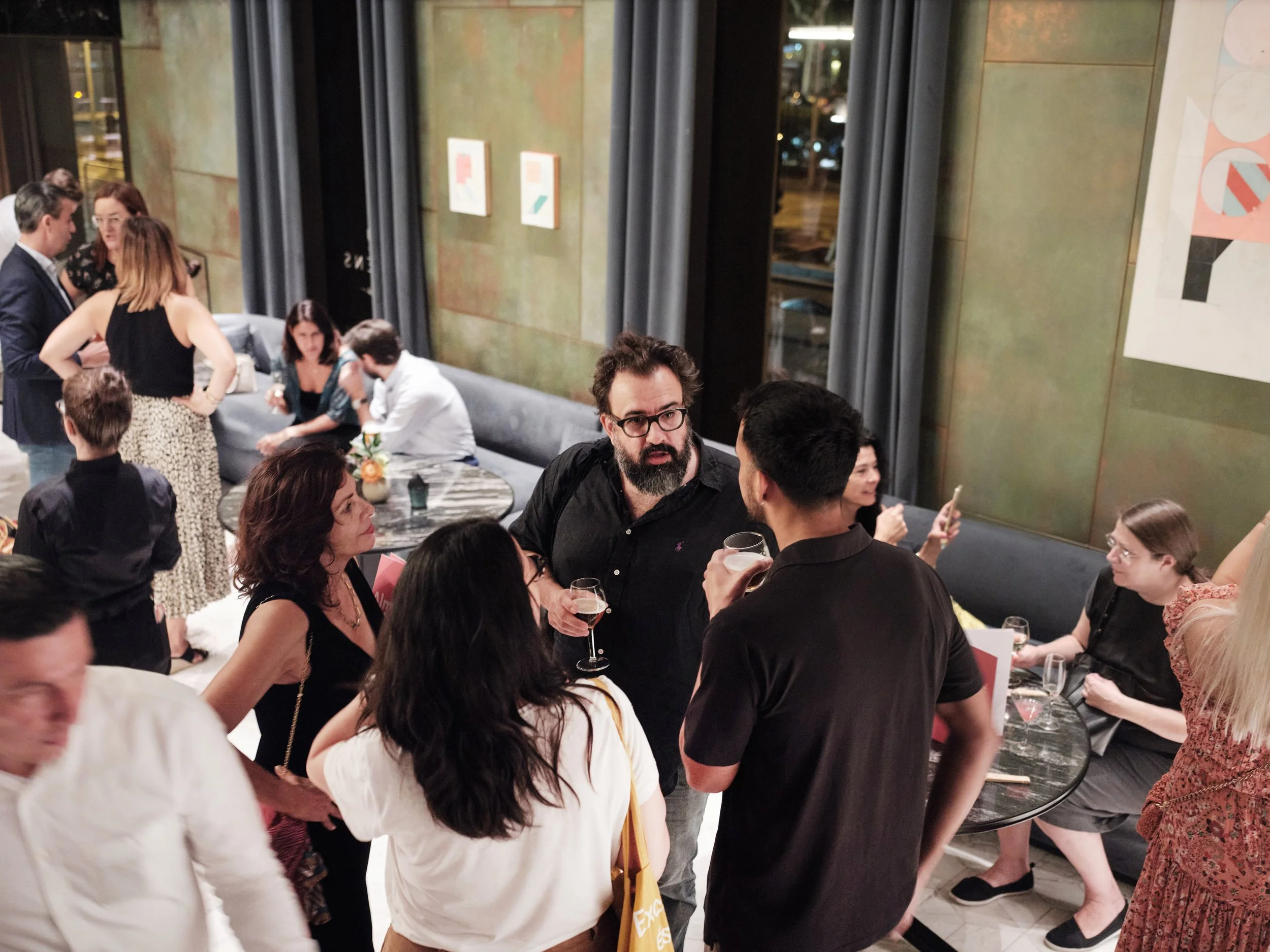 Guests at a Barcelona hospitality art presentation with works by Alberto Ruiz Villar installed in the restaurant interior.