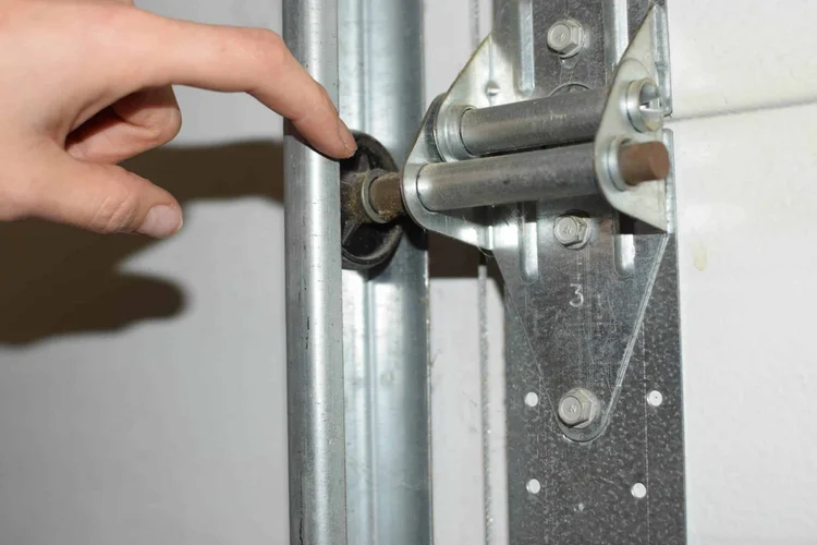 Garage door roller hardware being inspected