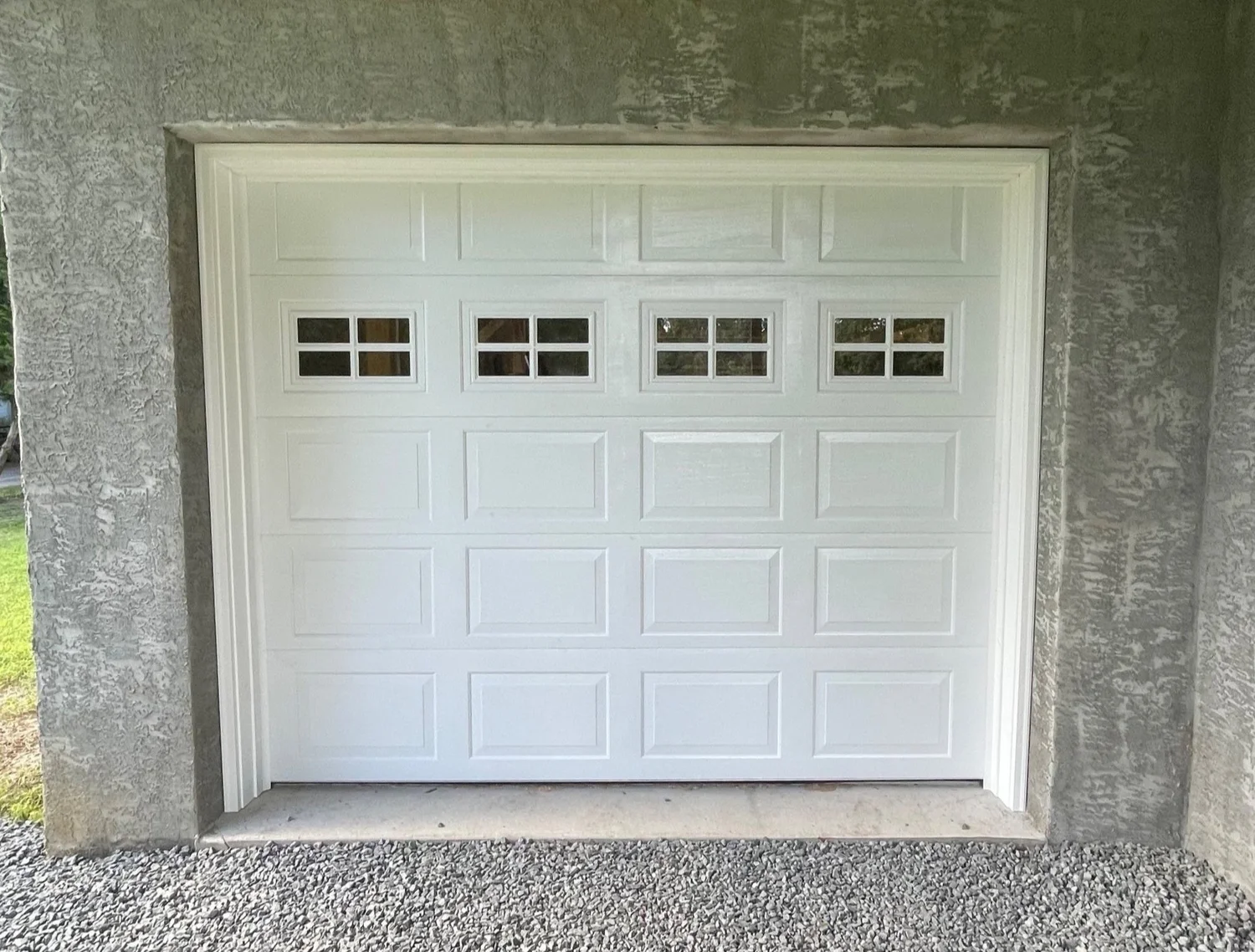 White garage door installed in a stone home