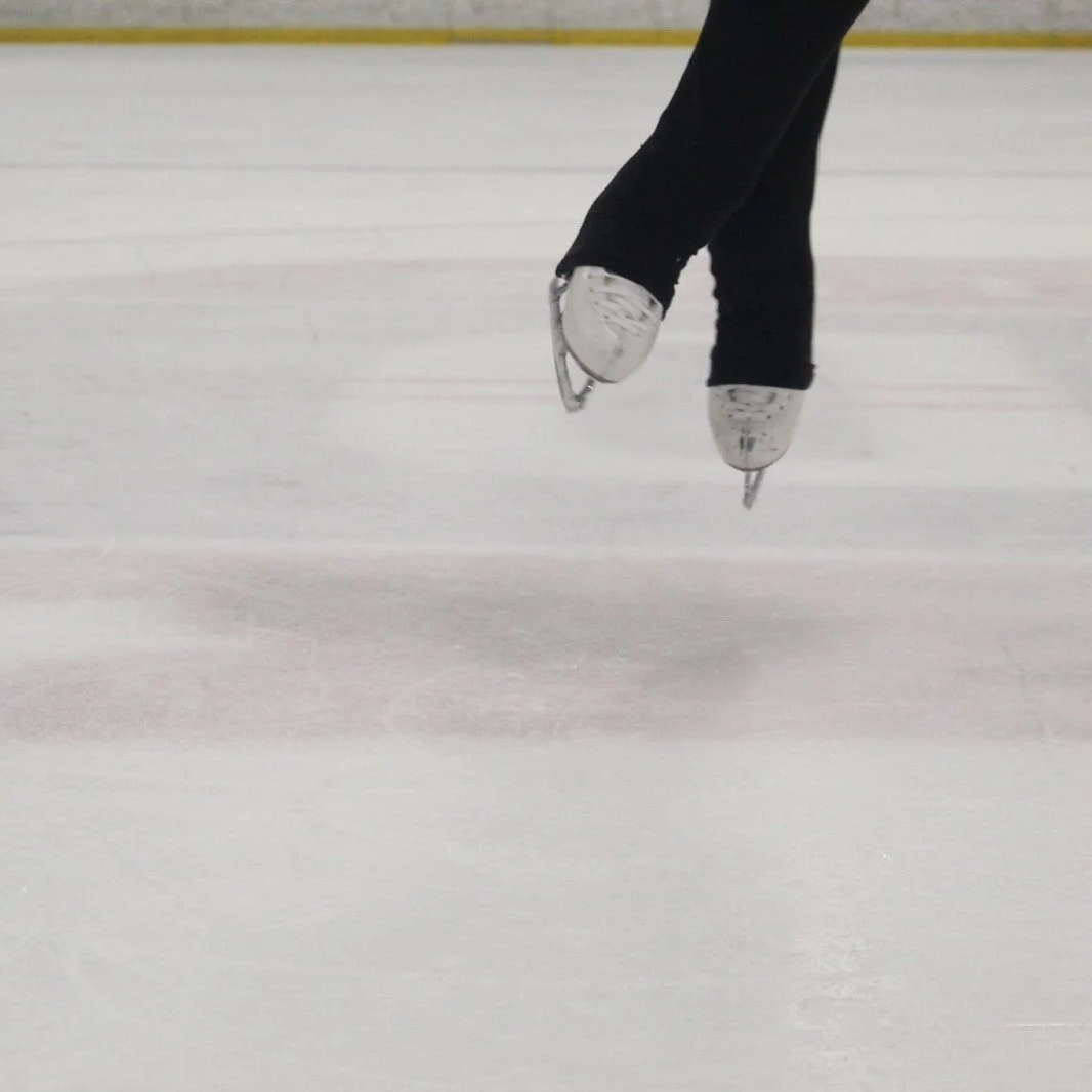 Figure skater in the air with legs crossed in air position