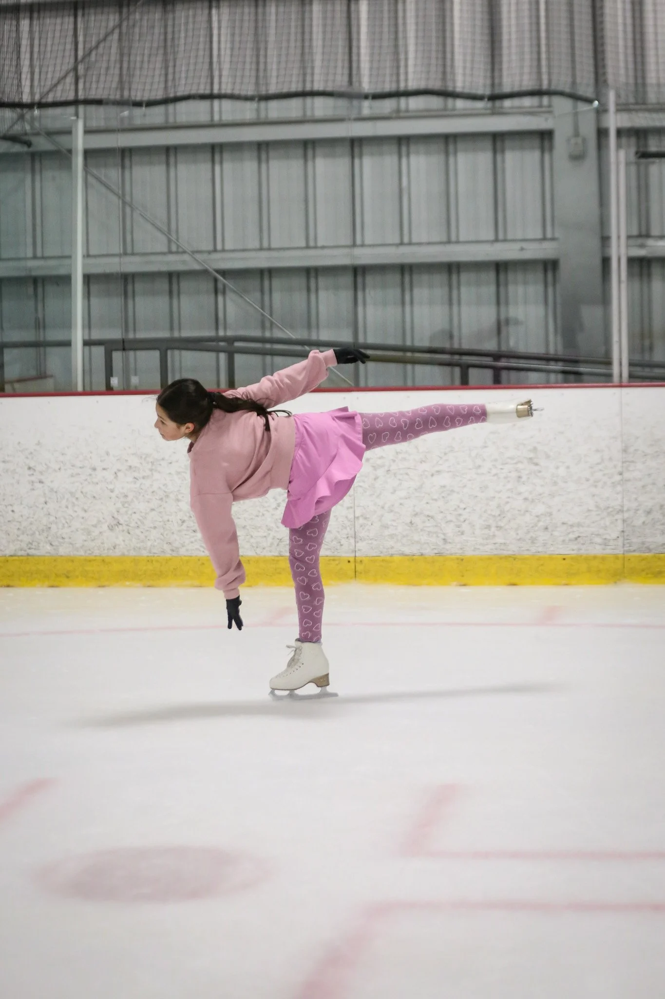 Skater performing a spiral on the ice during figure skating camp in Austin at Skate VIDA