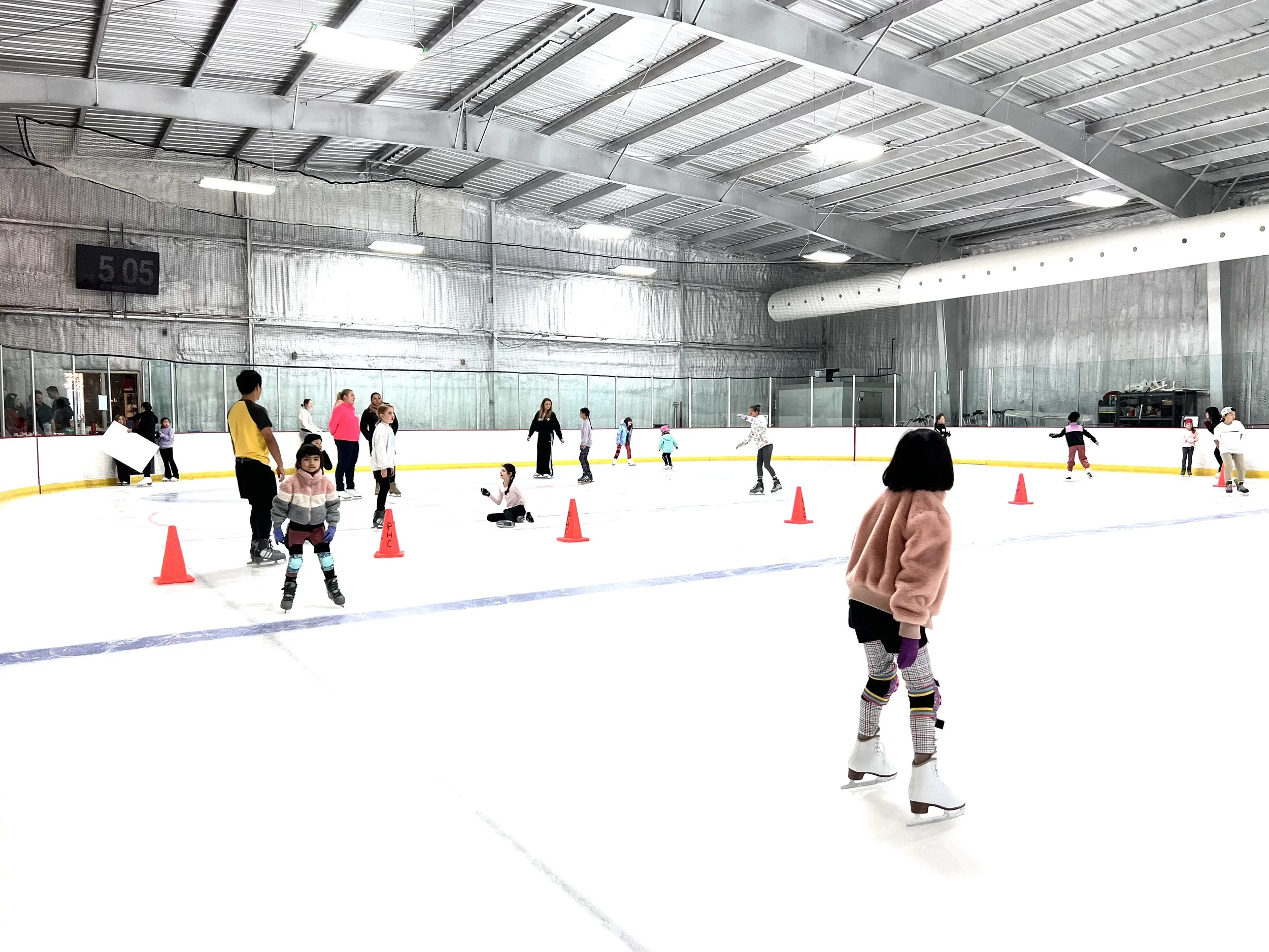 Young skaters in group class with cones on the ice