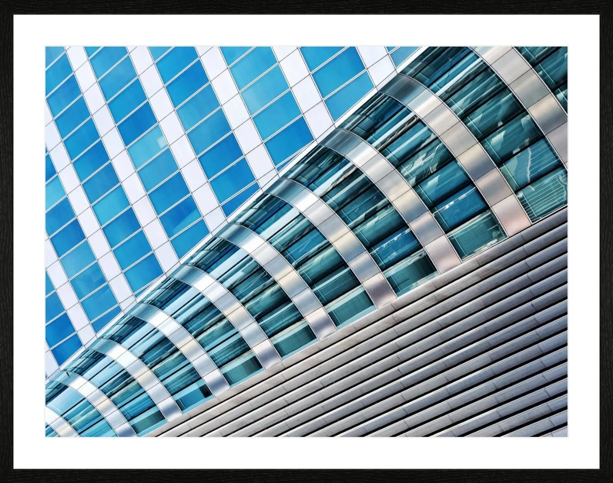 Moderne Gebäudefassade mit Glas und Metall, diagonale Perspektive.