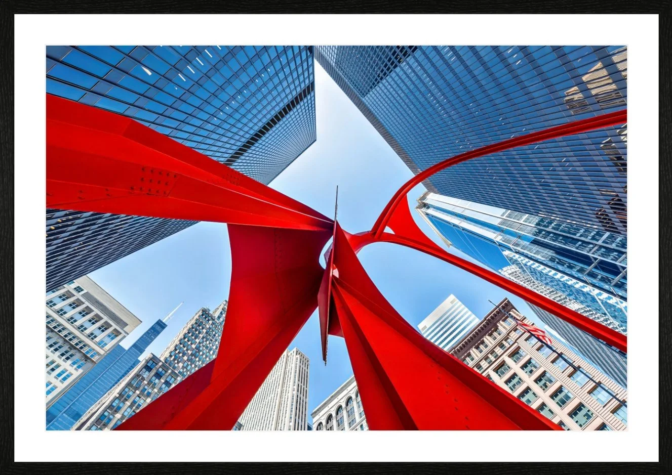 Blick nach oben auf moderne Wolkenkratzer mit Glasfassaden und eine große rote Skulptur in der Mitte der Stadt