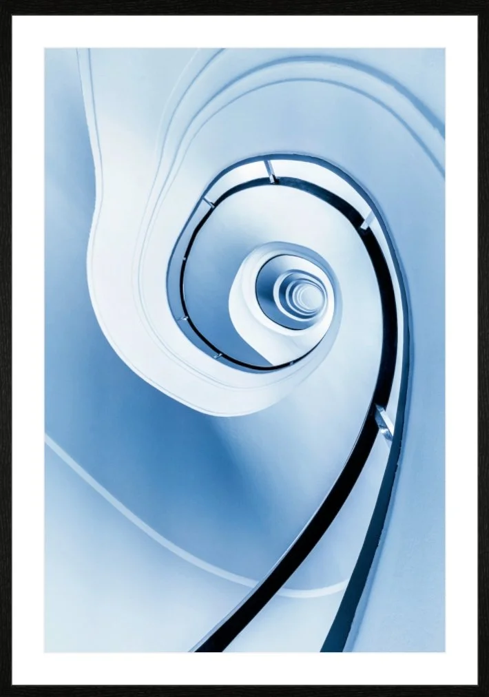 Innenaufnahme einer spiralförmigen Rolltreppe in Blau- und Weißtönen.