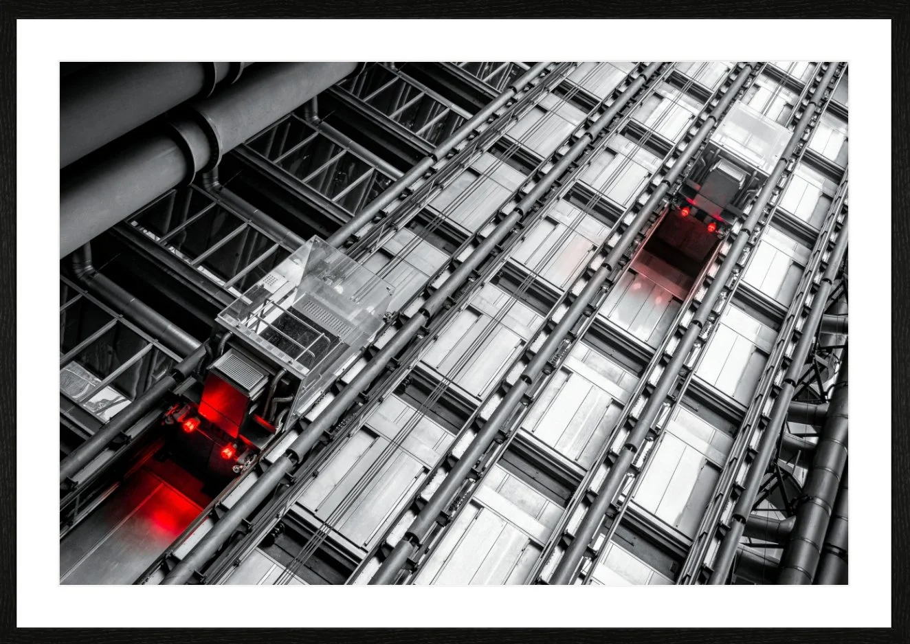 Blick auf die zentrale Hubschrauber-Liftanlage im Inneren eines modernen Hochhauses aus Metall und Glas, mit roten Warnleuchten