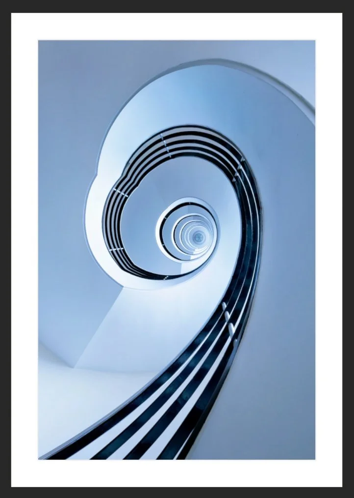 Innenansicht einer modernen, spiralförmigen Rolltreppe oder Treppe mit schwarzen Linien gegen weißen Hintergrund, perspektivisch nach oben gerichtet.