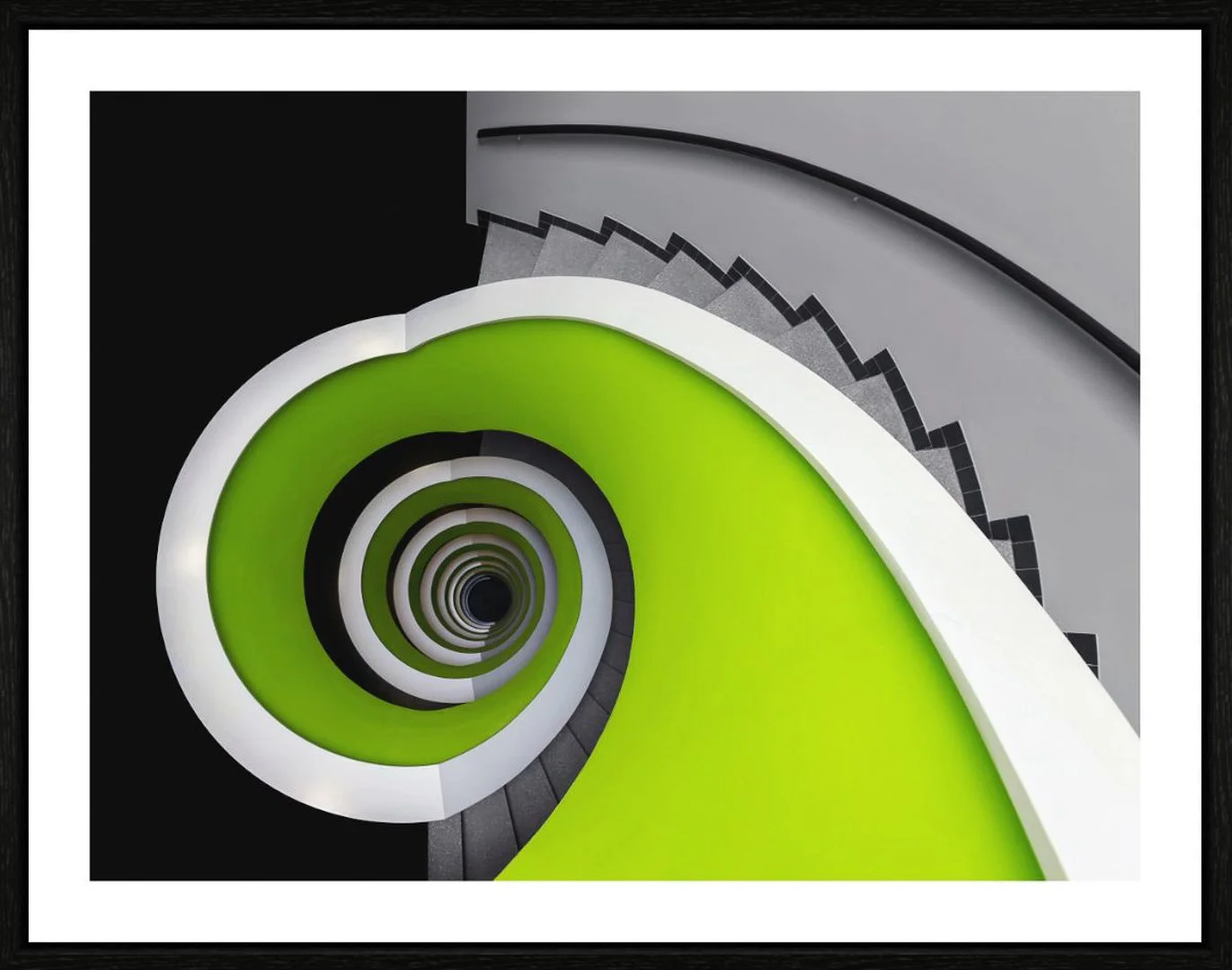 Innenaufnahme einer spiralförmigen Treppe mit grünen und weißen Stufen, die nach unten führt, Blick von oben nach unten.