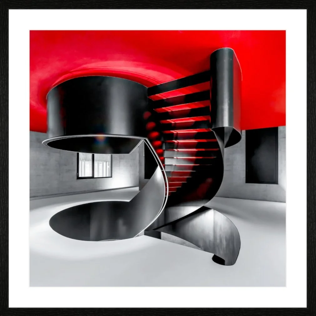 Ein modernes, künstlerisch gestaltetes Treppenhaus mit schwarzen Metallstufen und einer roten Decke in einem minimalistischen Raum.