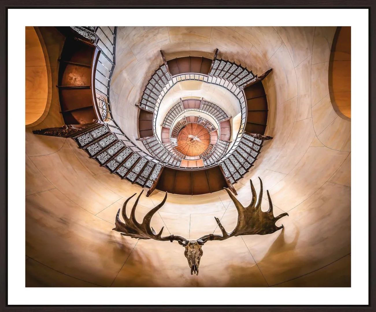 Innenansicht eines spiralförmigen Treppenturms mit einem Geweih eines Elchs an der Wand.