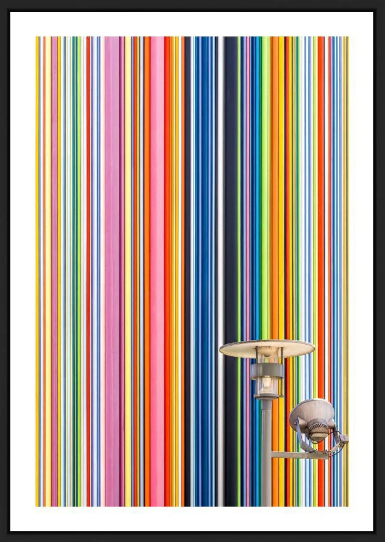 Ein modernes Kunstwerk mit bunten vertikalen Streifen und einem Straßenlaternen und einem Sitzsack im Vordergrund.