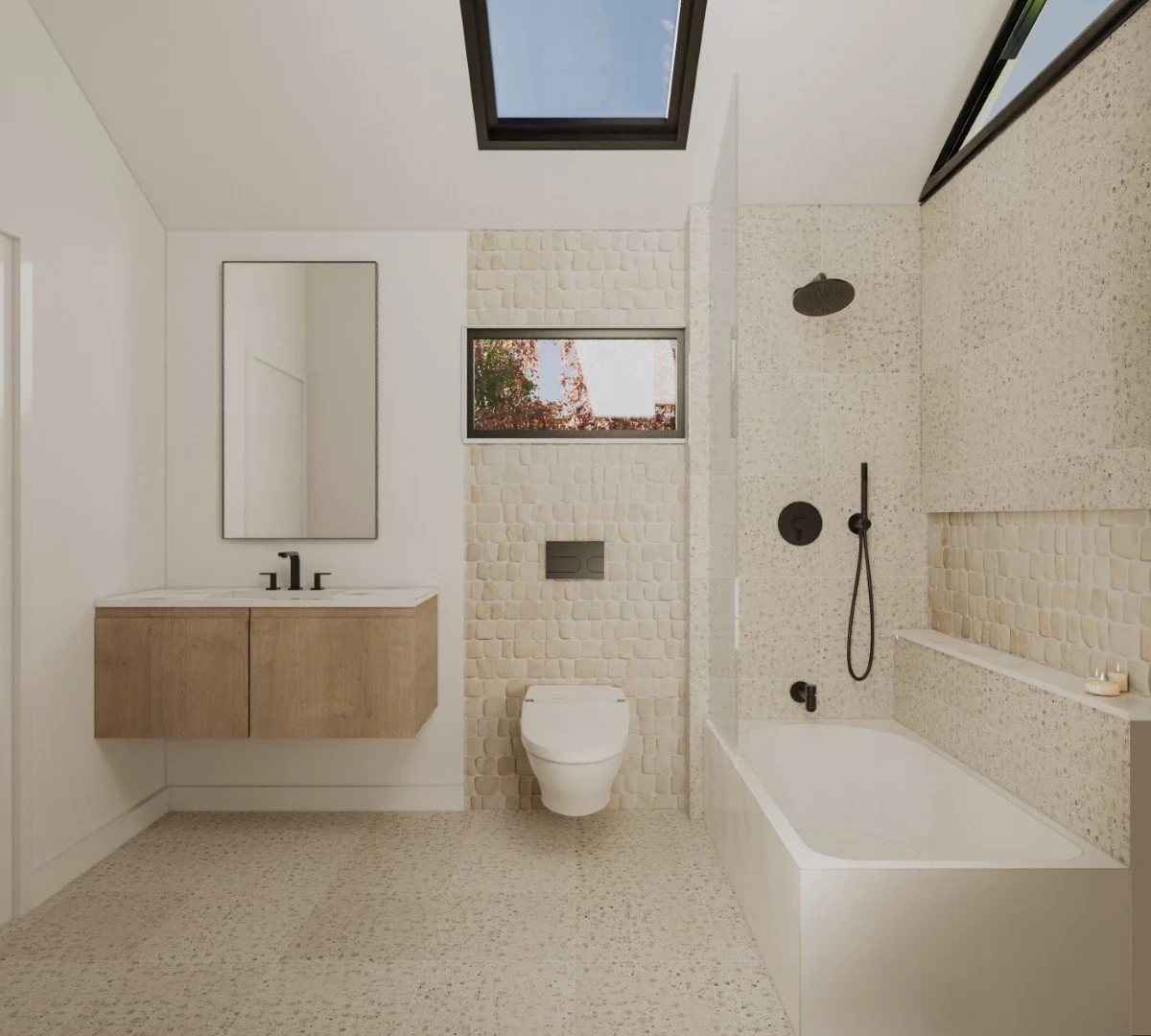 Modern bathroom with a bathtub, shower, toilet, and vanity with mirror, featuring light-colored tile and pebble-textured wall accents, a window, and a skylight.