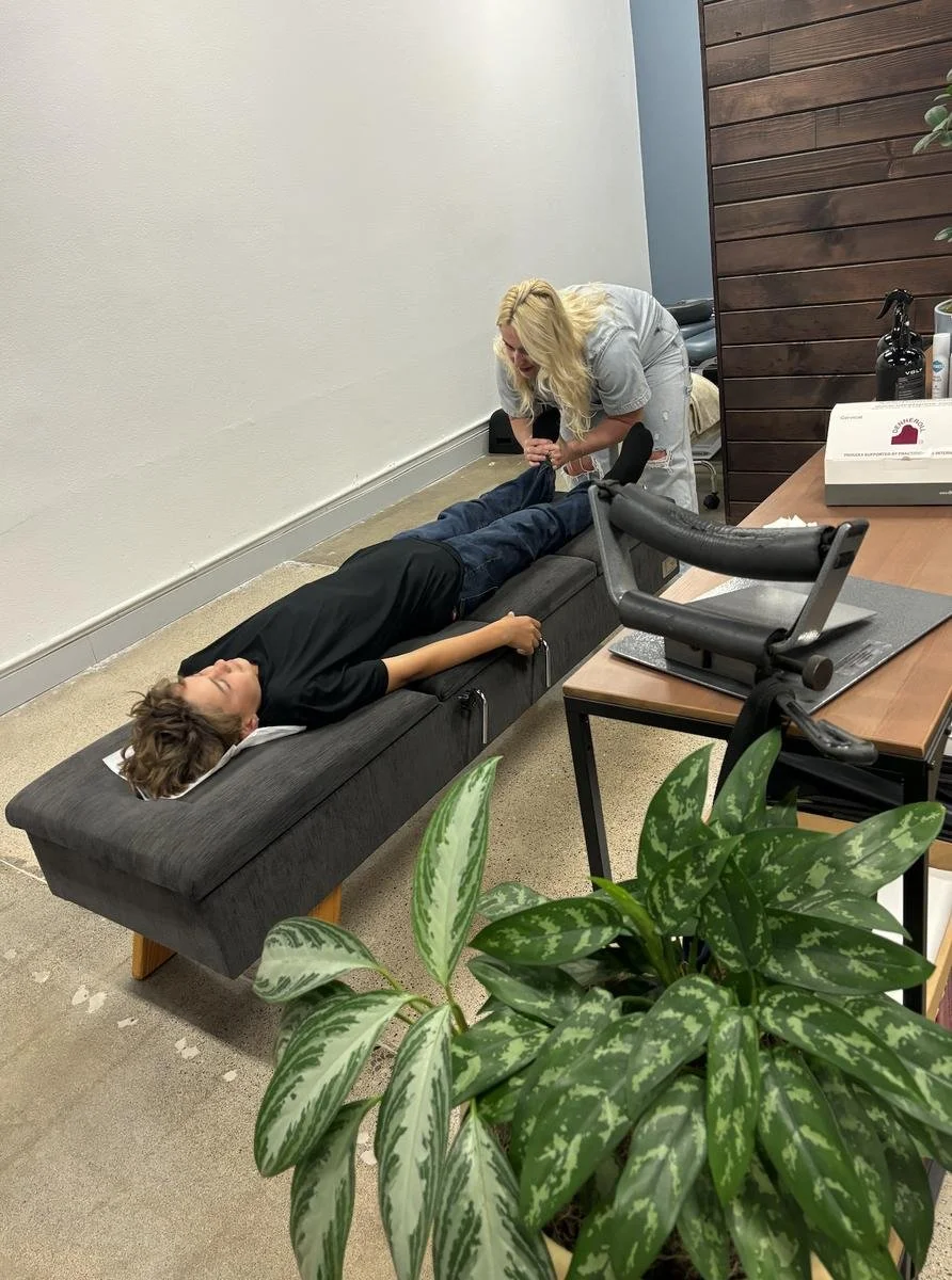 Chiropractor adjusting a teenage patient to support nervous system regulation