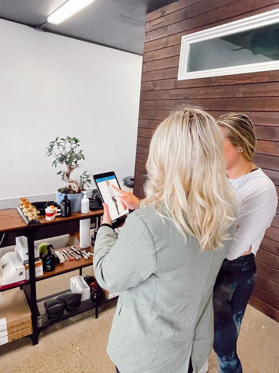 Chiropractic consultation reviewing scoliosis care on a tablet