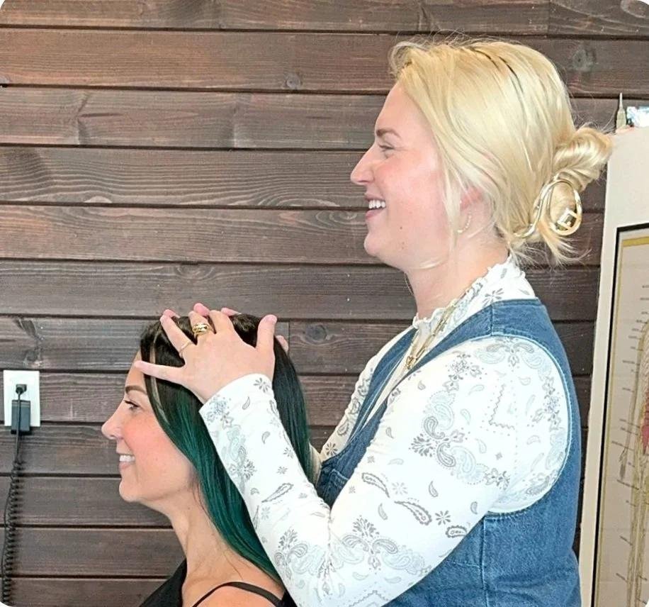 Chiropractor performing a gentle neck adjustment on a smiling patient in Huntington Beach