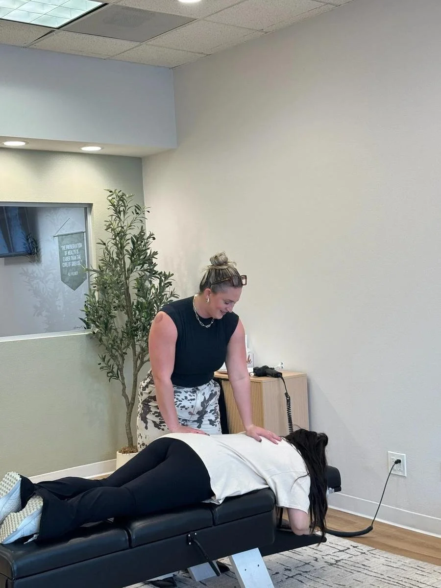 Chiropractor performing a gentle mid-back adjustment to ease stress and tension