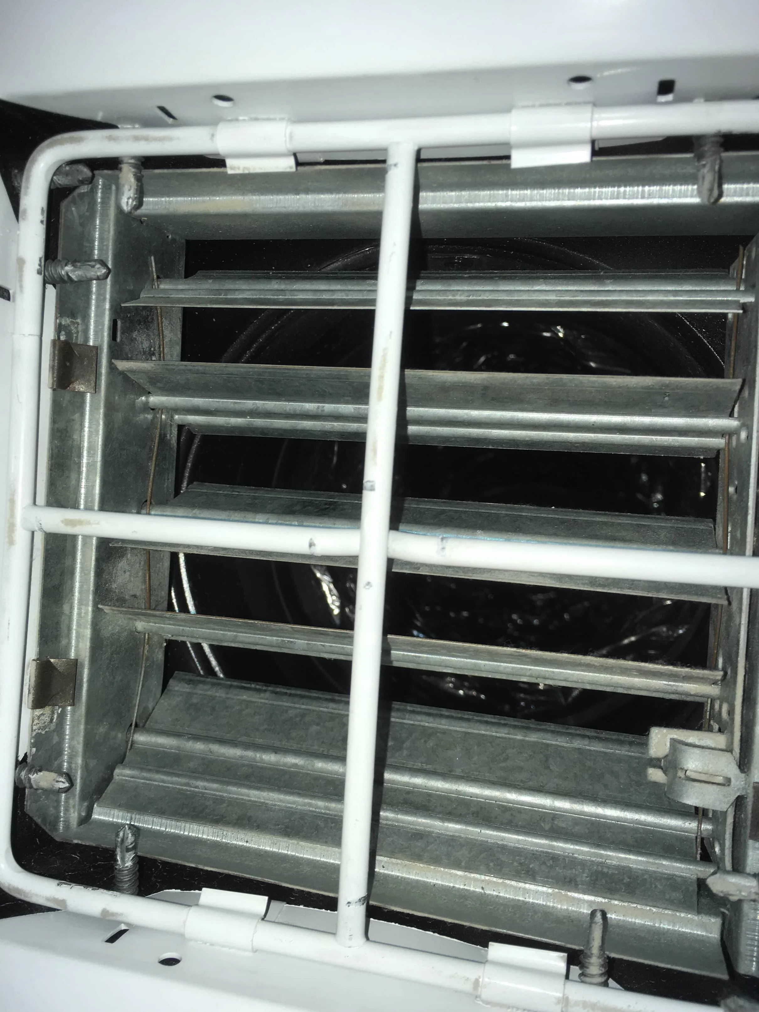 View of the inside of a dryer, showing the metal drum and lint filter.