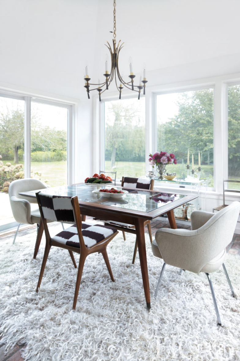 Photographs by Marili Forastieri; Upholstered chairs by Gio Ponti and Eero Saarinen surround a glass-top table in the airy dining room.