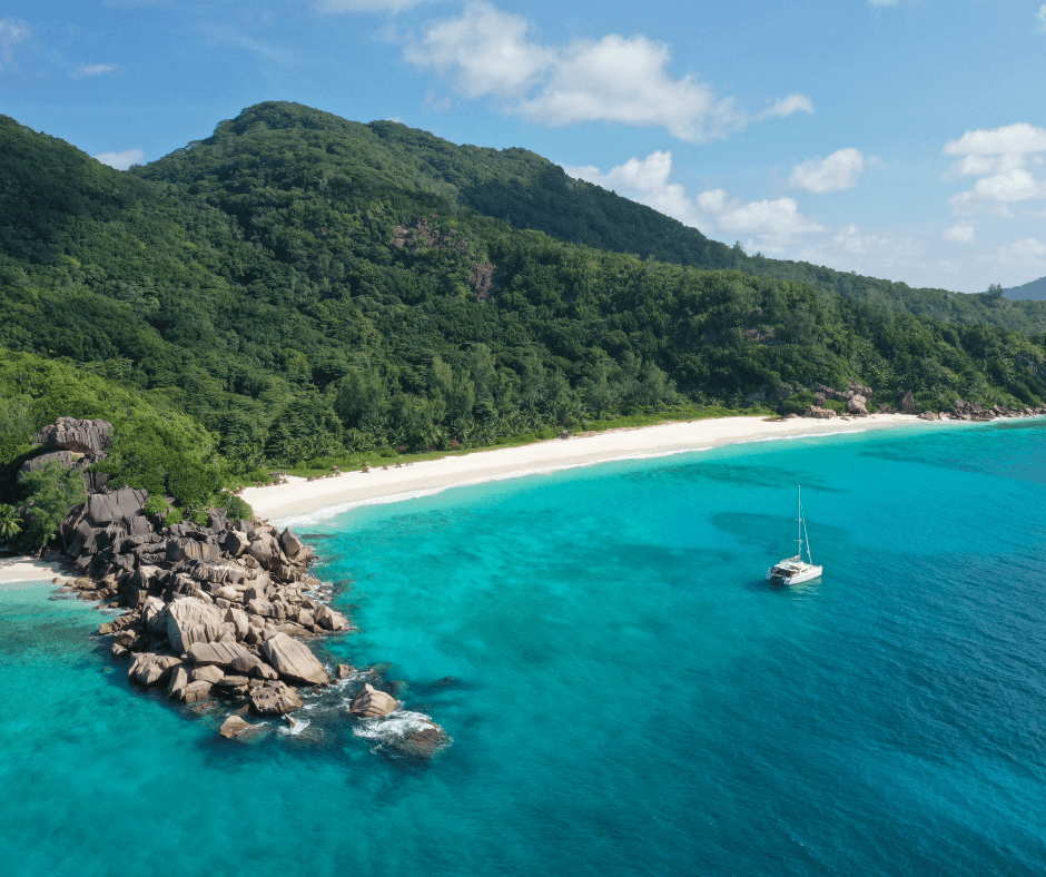 Seychelles beach wtih yacht in the water