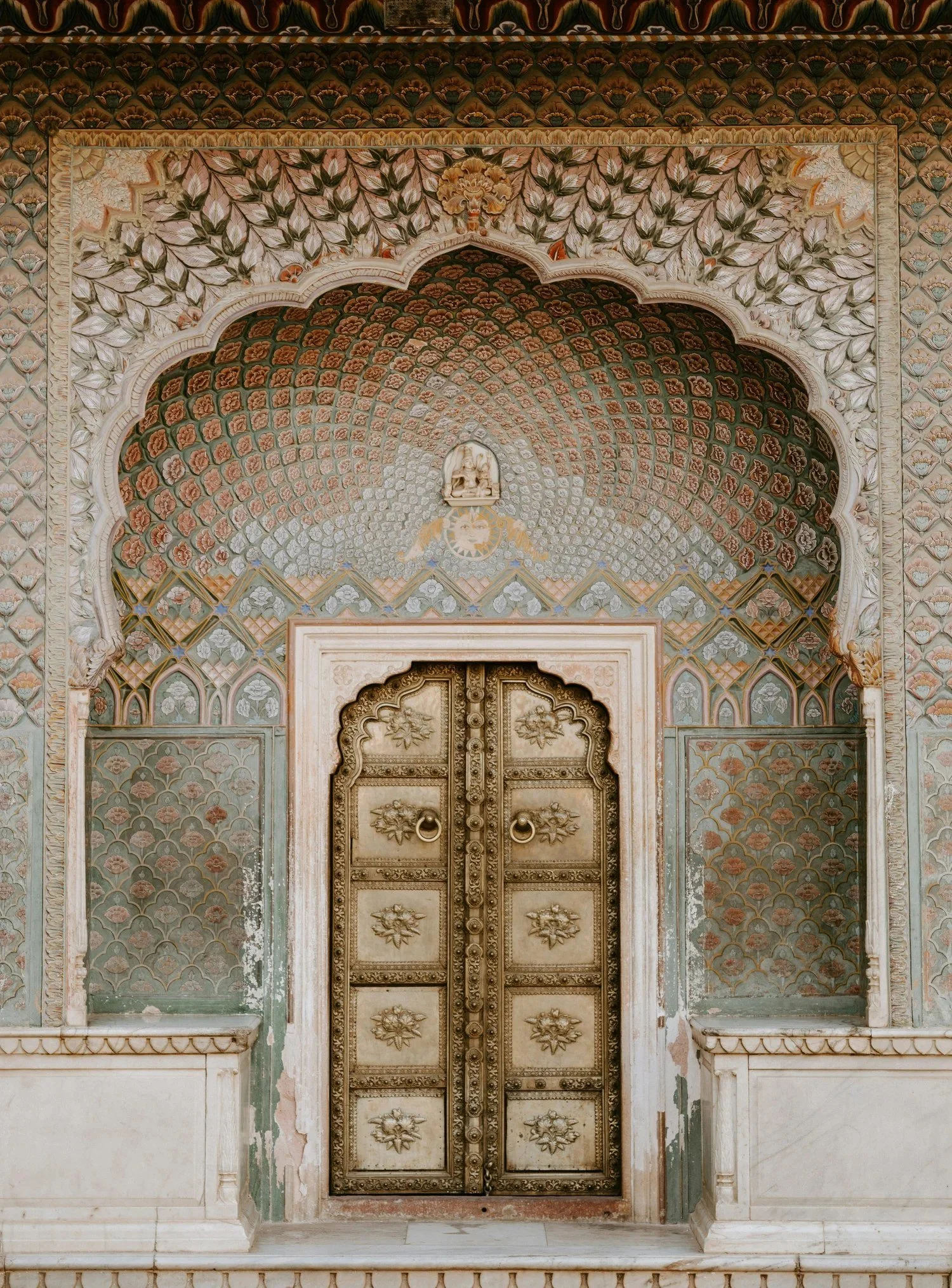 Ornate painted archway and brass door in a historic palace