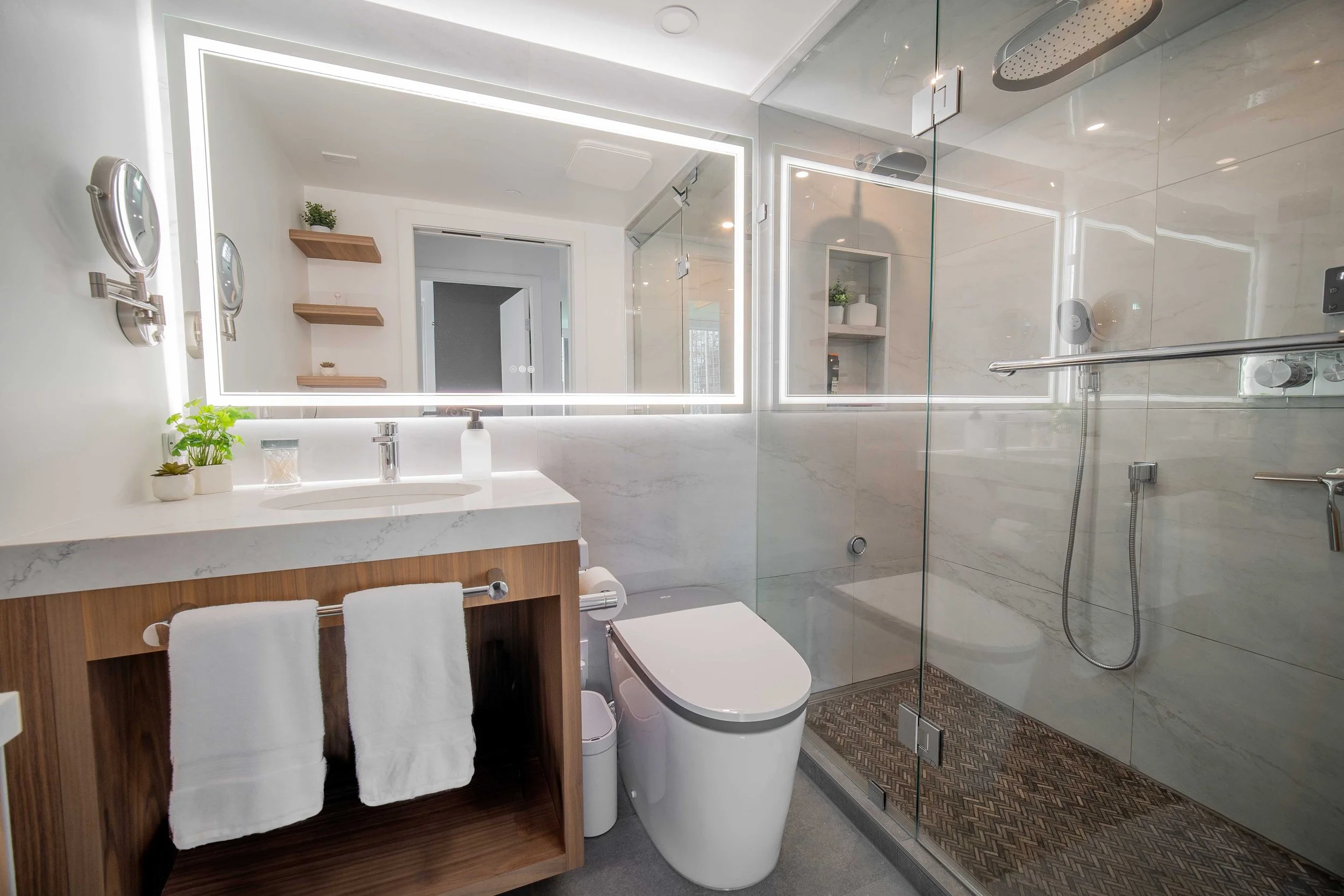 West Georgia condo renovation by WorkPro Contracting: Bathroom photograph featuring a steam shower, smart toilet, and LED fog-free mirror.