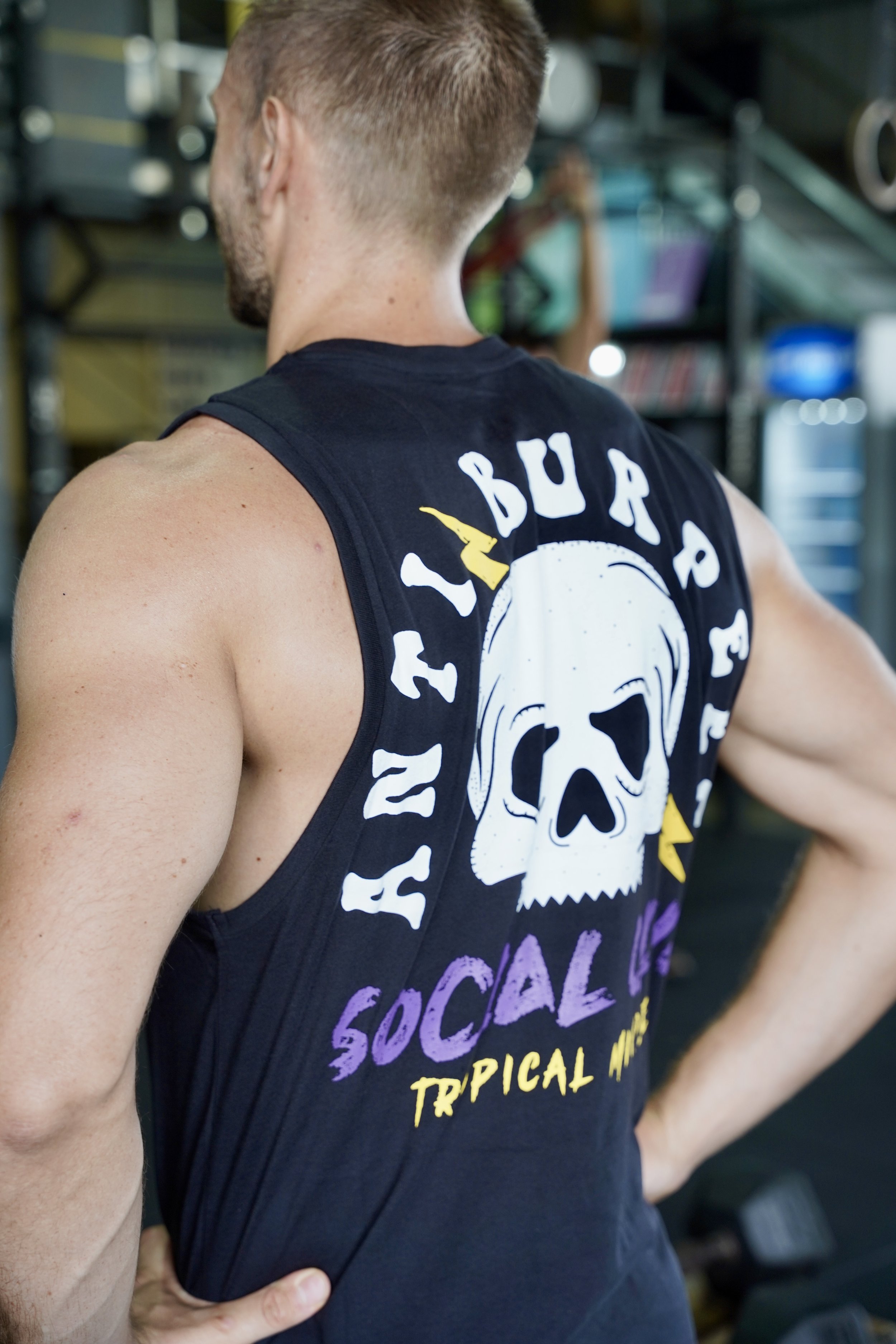 L’image montre homme de dos vêtu d’un singlet noir avec comme logo une tête de mort et des éclairs