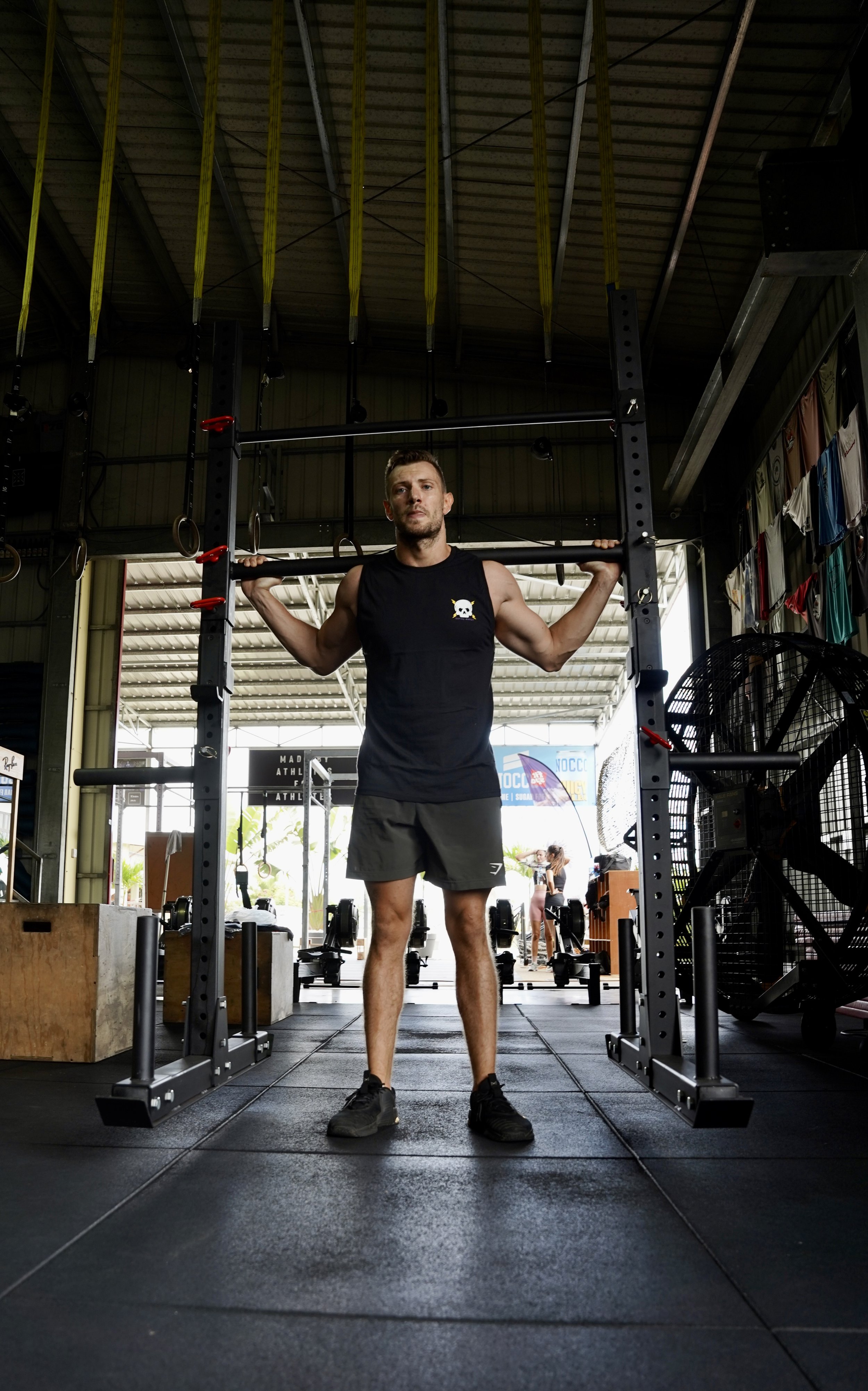 L’image montre un homme faisant du sport et vêtu d’ un singlet noir avec comme logo une tête de mort et des éclairs sur la poitrine
