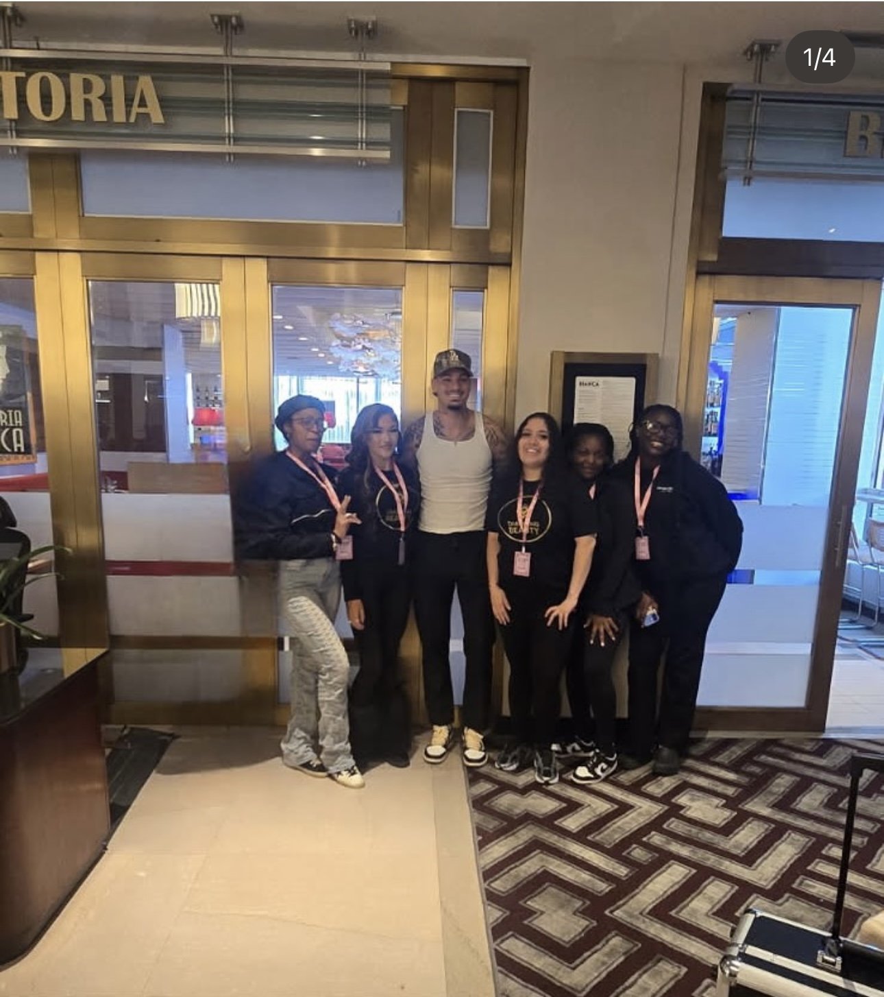 Group of six people standing in front of a restaurant entrance, smiling for the photo.
