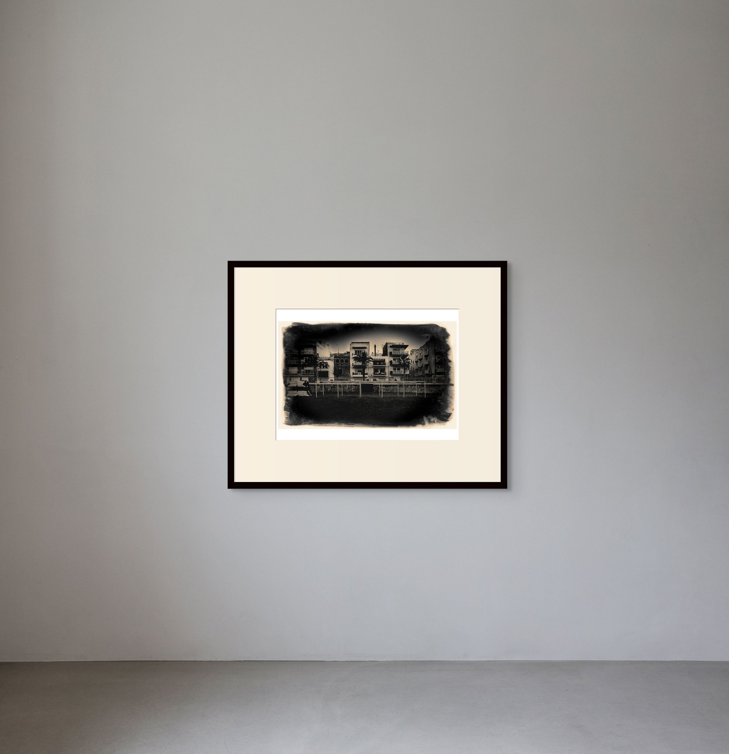Black and white abstract artwork framed on a light gray gallery wall.