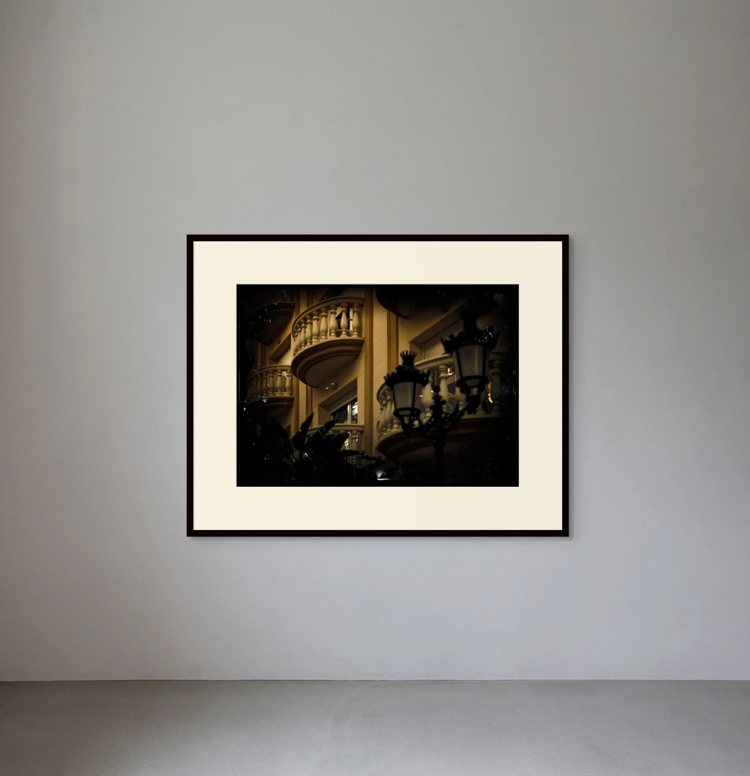 Framed photograph of ornate buildings and street lamps on a gallery wall.