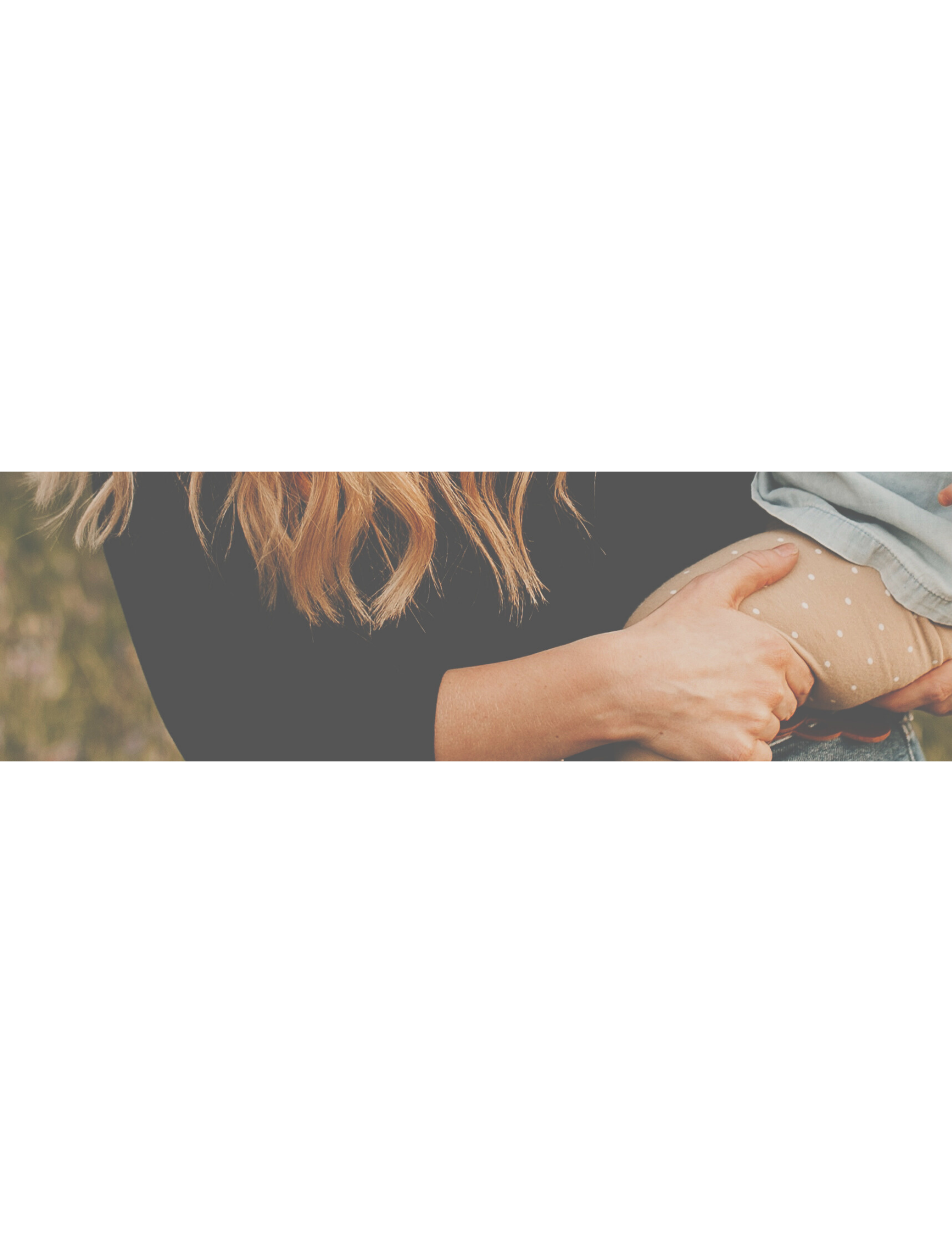 A woman holding a child's hand, with focus on their hands and part of the woman's arm and hair visible, outdoors setting.