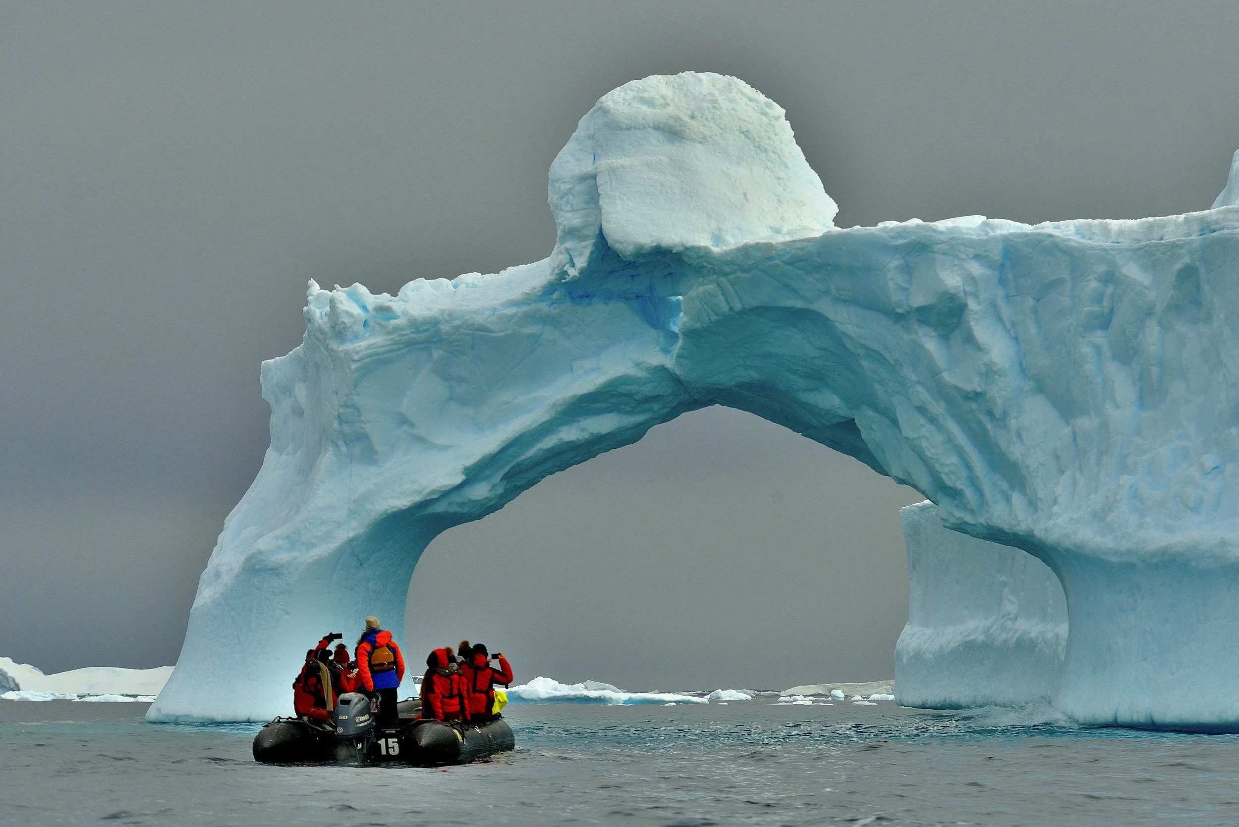 Photo of small raft floating near iceberg in Antarctica