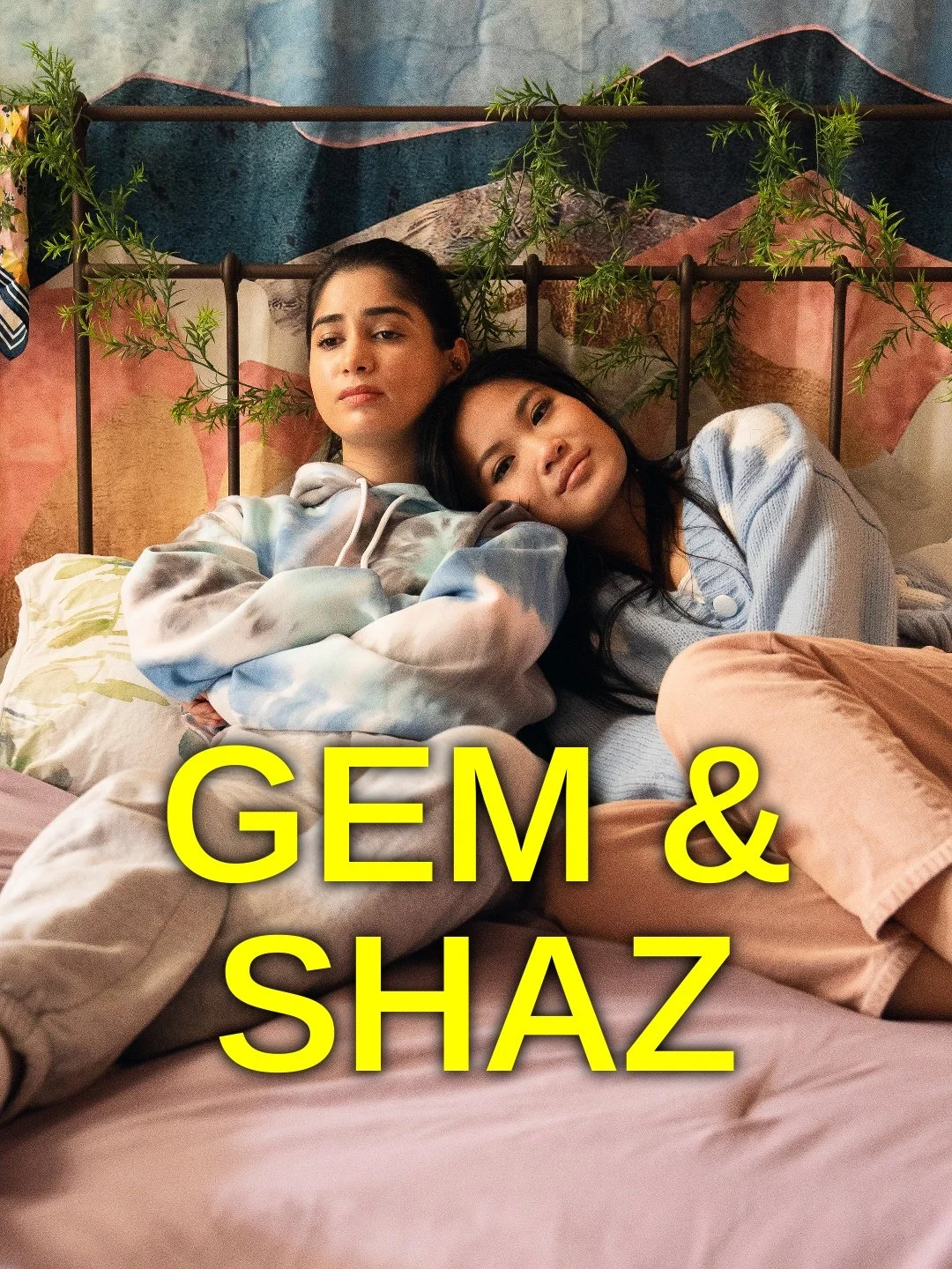 Two women lying on a bed with a backdrop of mountain art and greenery, one resting her head on the other's shoulder, with the text 'GEM & SHAZ' in yellow across the bottom.