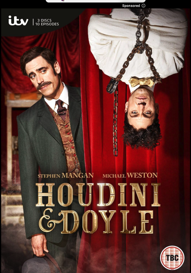 Poster for the play 'Houdini & Doyle' featuring actors Stephen Mangan and Michael Weston, with Stephen Mangan dressed in period costume and Michael Weston upside down with curly hair hanging from chains, set against red theater curtains.