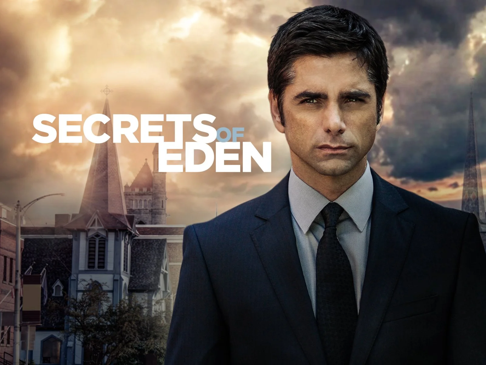 Promotional poster for the TV show 'Secrets of Eden' featuring a man in a suit with a serious expression, standing in front of a background of cloudy sky and cathedral spires.