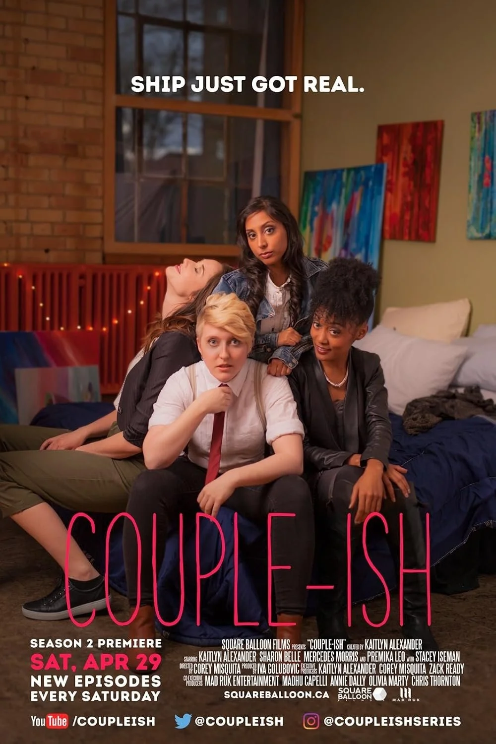 A promotional poster for the TV series 'Couple-ish' with four women in a room. One woman with blonde hair and a tie sits in the front, another woman with curly hair and a black jacket sits beside her, a woman with long dark hair and a denim jacket st