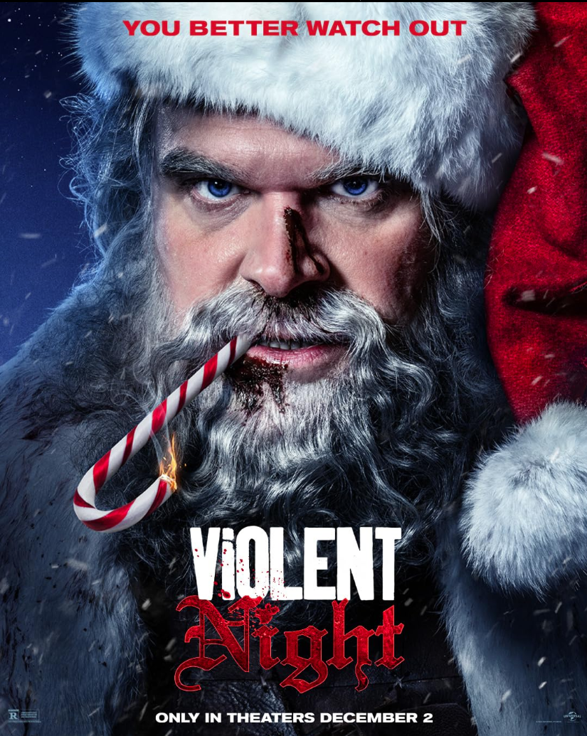 Close-up of a man dressed as Santa Claus with a serious expression, holding a candy cane in his mouth. He has a white beard, blue eyes, and wears a red Santa hat. There is text at the top that says 'YOU BETTER WATCH OUT' and at the bottom 'VOLTENT Ni