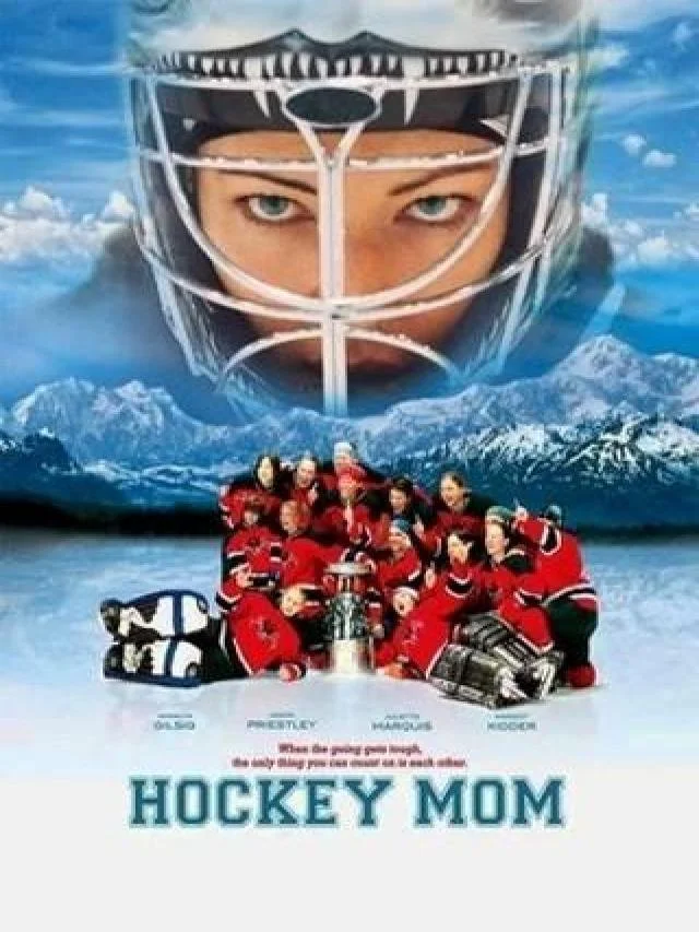 Poster for the movie 'Hockey Mom' featuring a giant hockey goalie mask with a person's eyes visible through the net part, towering over a group of young hockey players in red jerseys and hockey gear kneeling on the ice, with snowy mountain scenery in