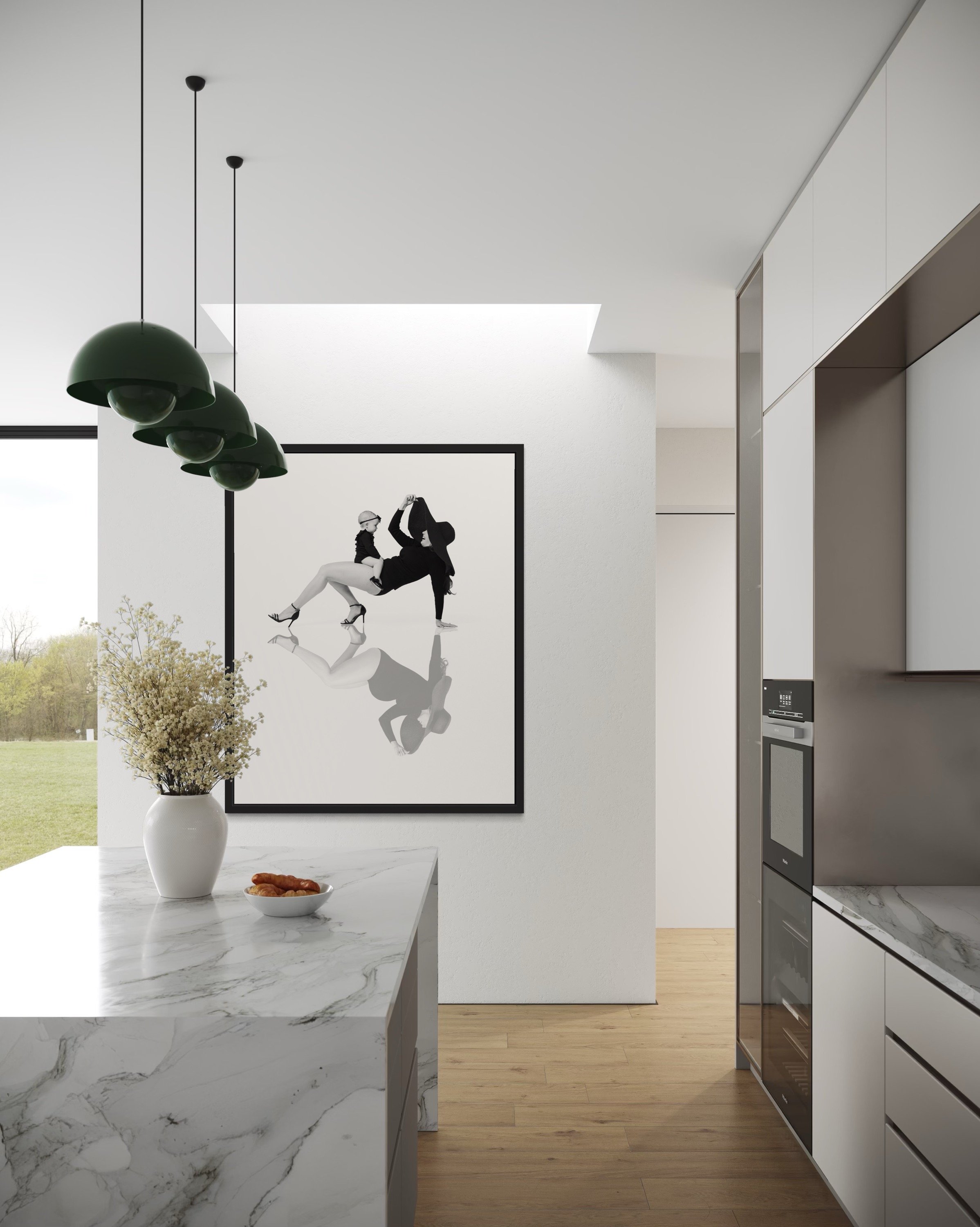 Modern kitchen with white walls, marble island, black pendant lights, artwork of two women in black and white, vase with flowers, bowl of pastries, and built-in appliances.