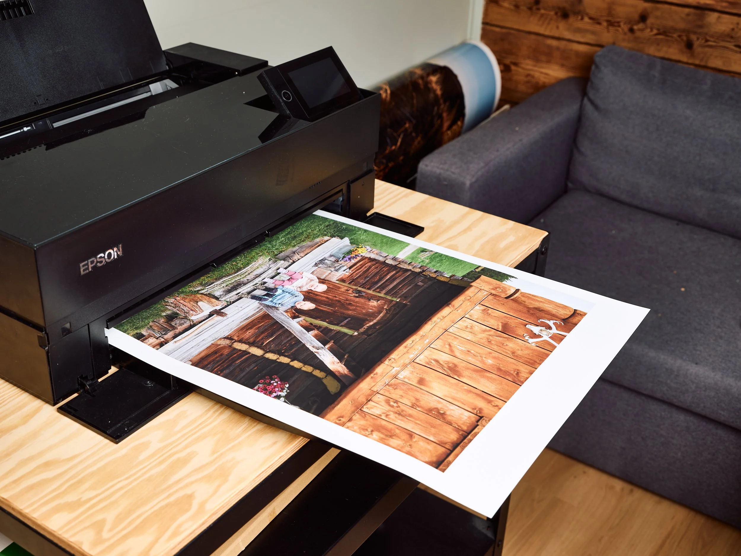 Skriver ut et fotografi av en hage med tre personer og en trelåve.