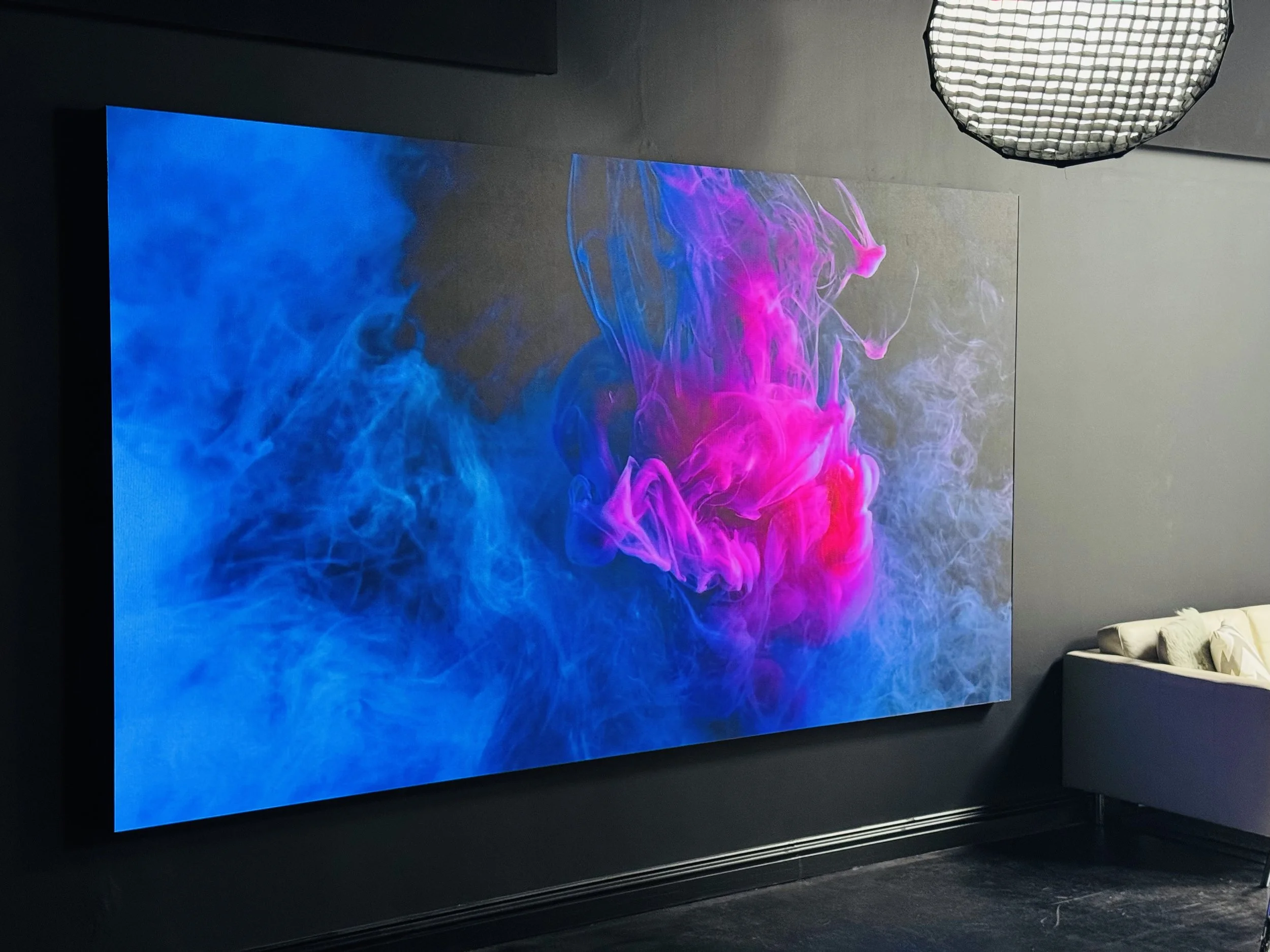 Virtual backdrop displaying vibrant pink and purple smoke swirling against a dark blue background.