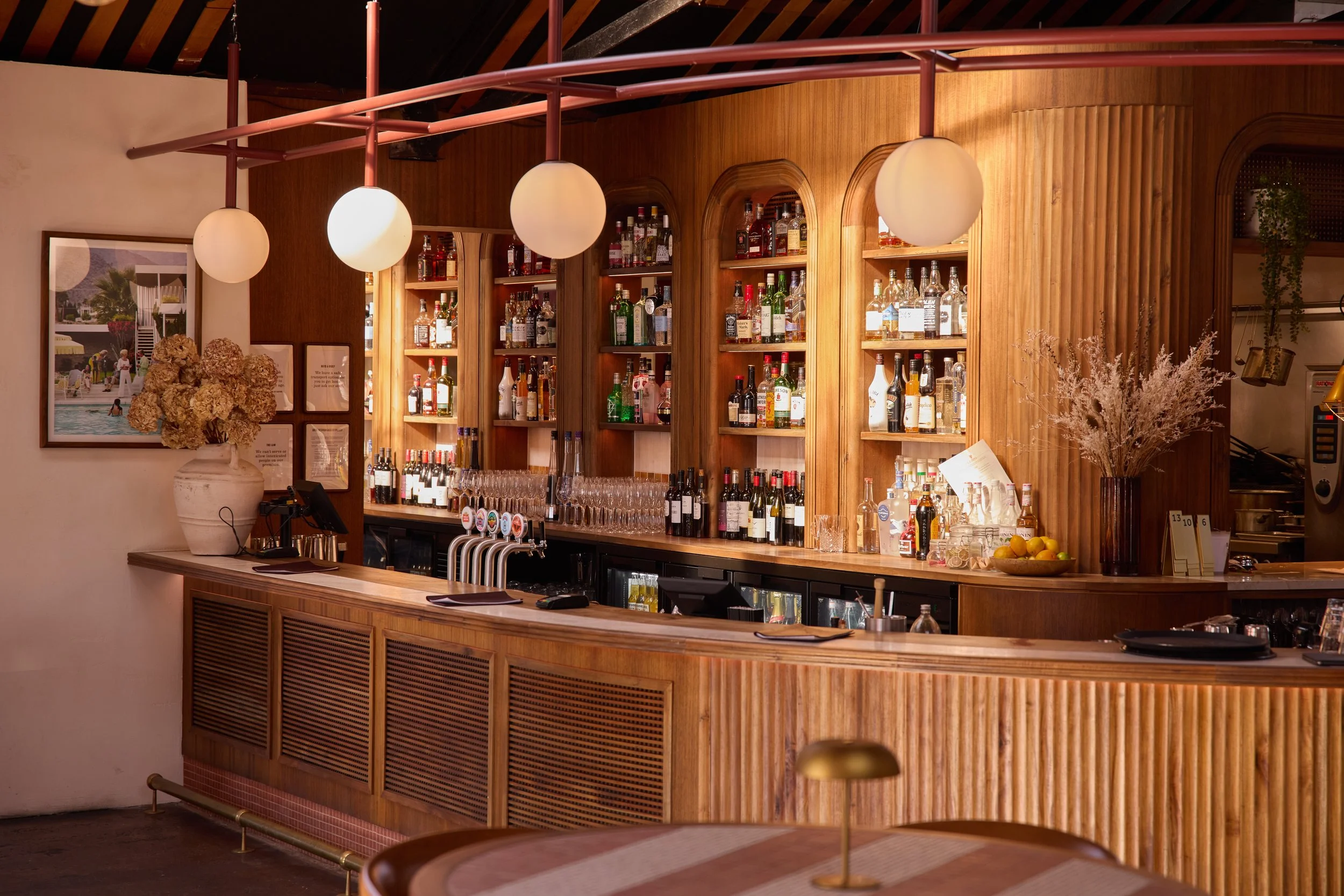 The timber bar at La Zeppa with pendant lights and a fully stocked back bar.