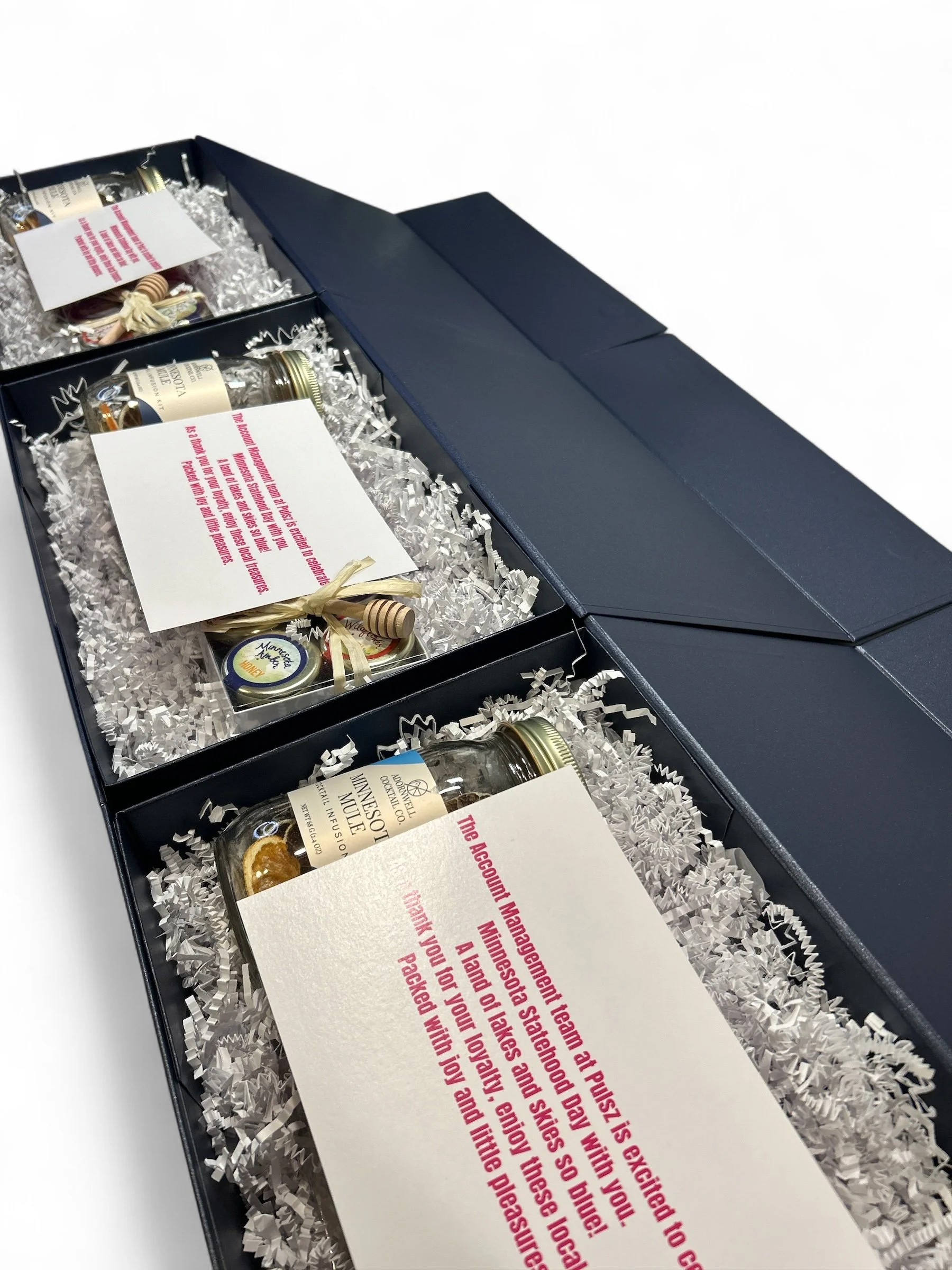 blue gift box with local Minnesota goods and company card on top.