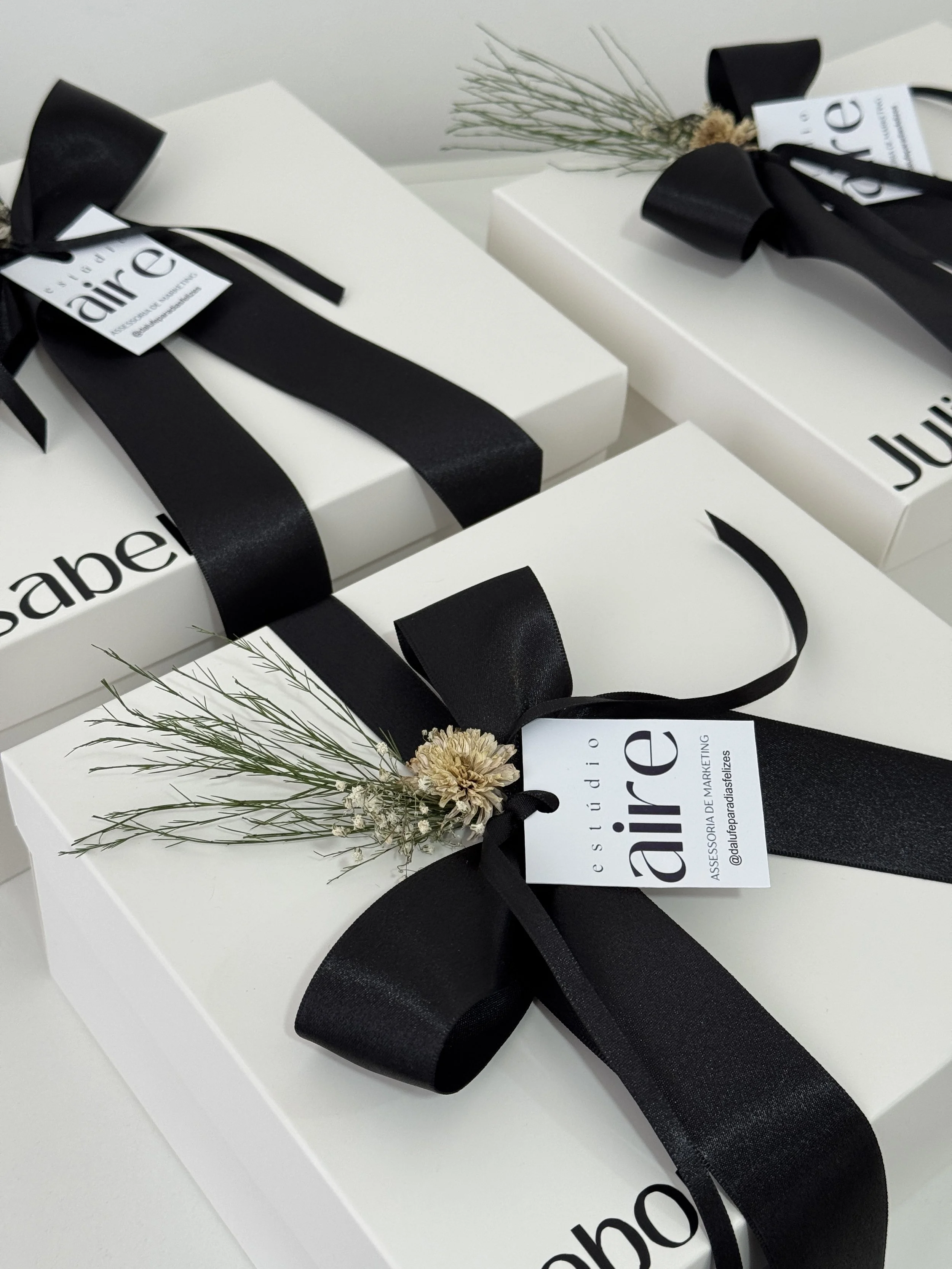 Gift Box Wrapped with Black Ribbon and Dried Flower Accent.