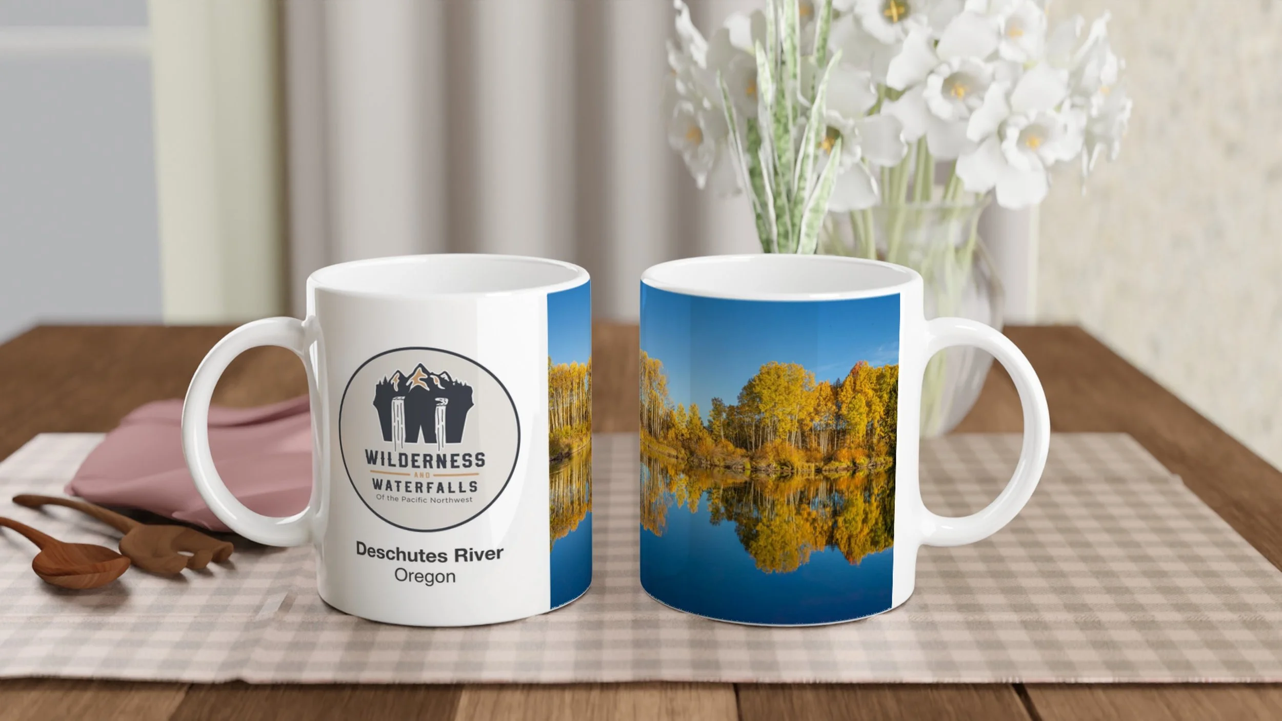 Two views of the same Deschutes River autumn photo mug on a dining table, showing the logo and golden trees reflected in the river.