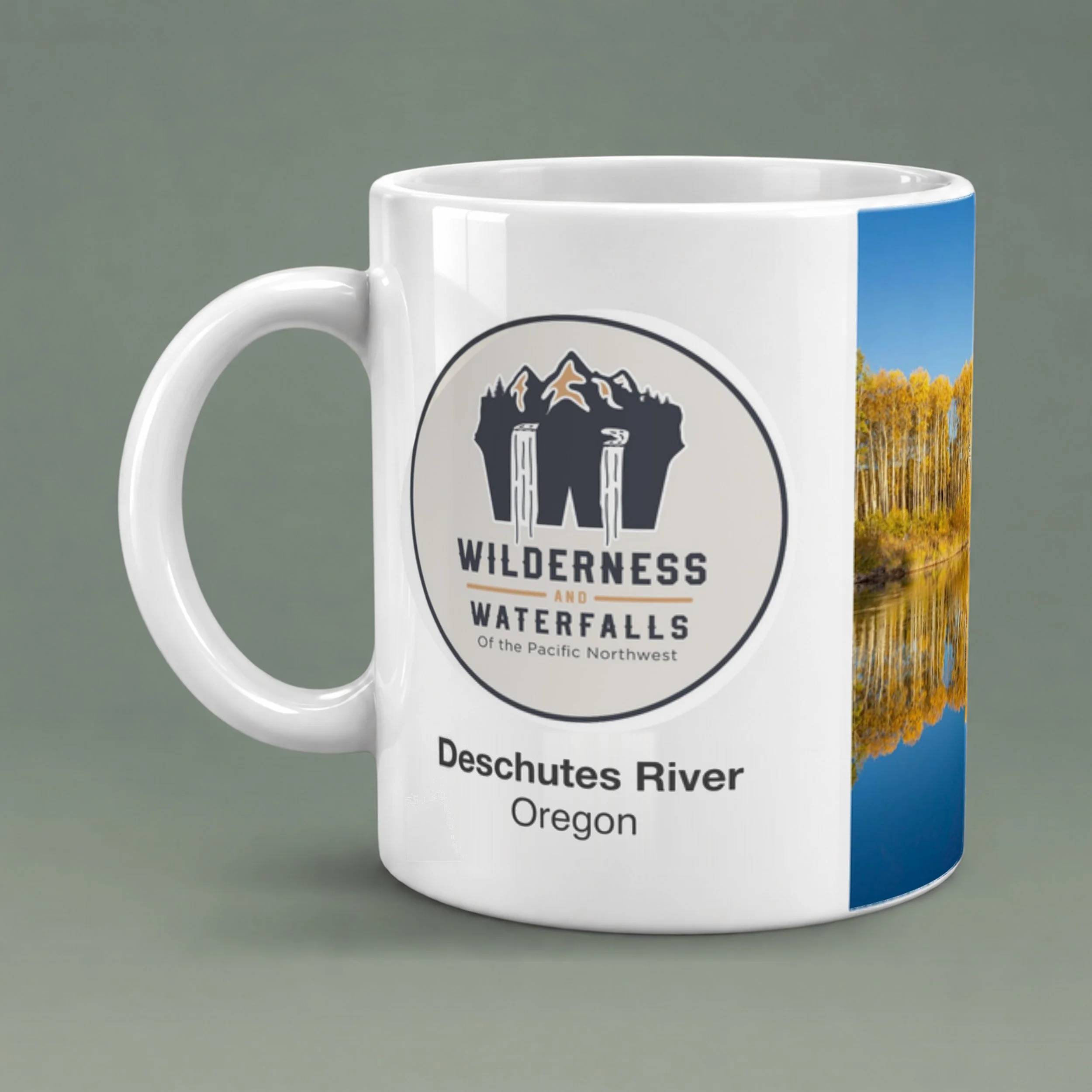 White ceramic mug showing the Wilderness & Waterfalls logo and Deschutes River, Oregon text, with glossy ceramic and a shaded rounded handle.