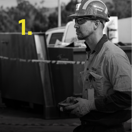 Construction worker wearing safety glasses and a helmet at a job site.