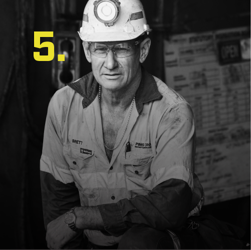 Man in a work uniform with a hard hat and glasses, number 5 in yellow
